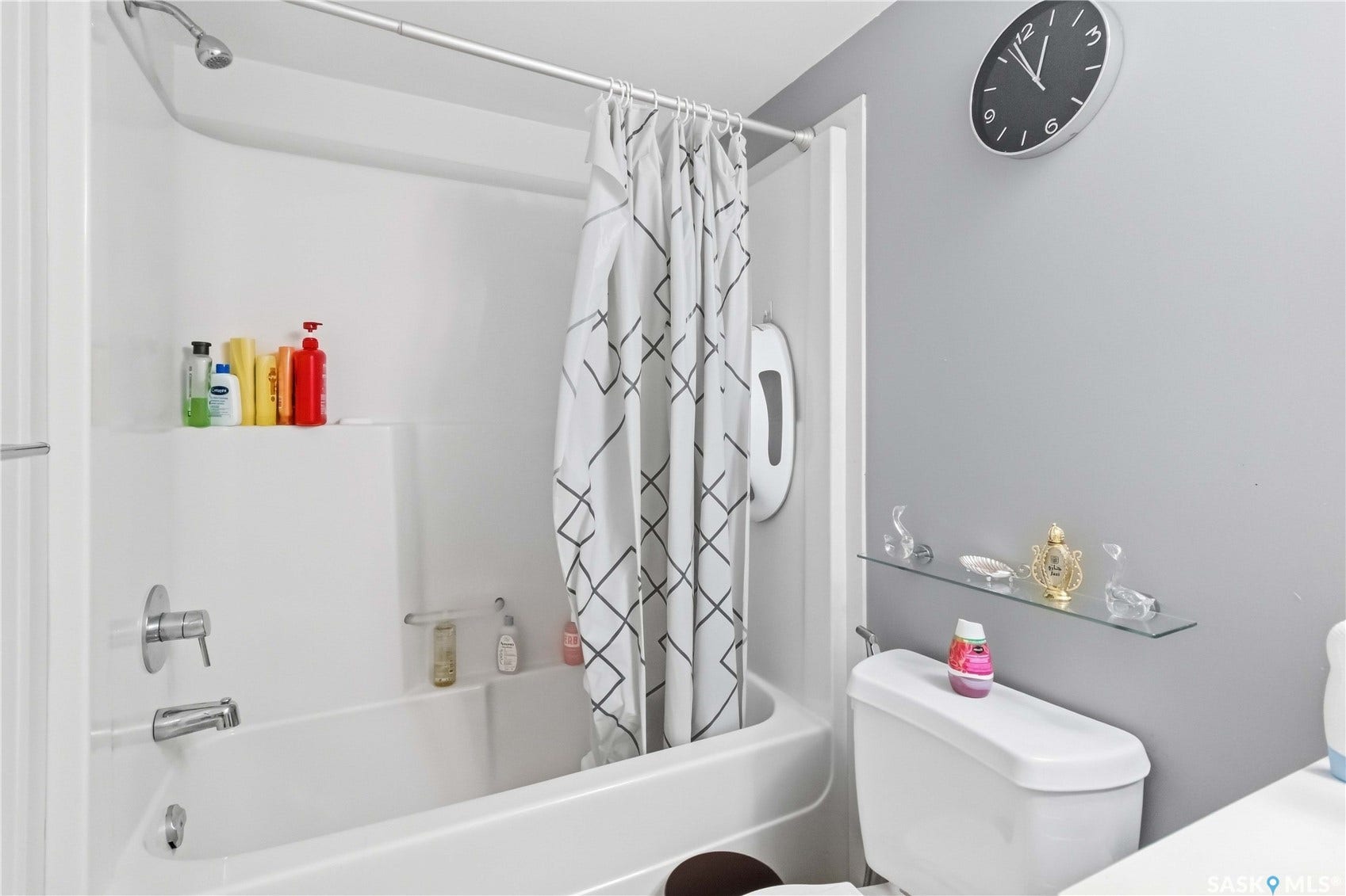 White bathtub/shower combination with a built-in shelf
