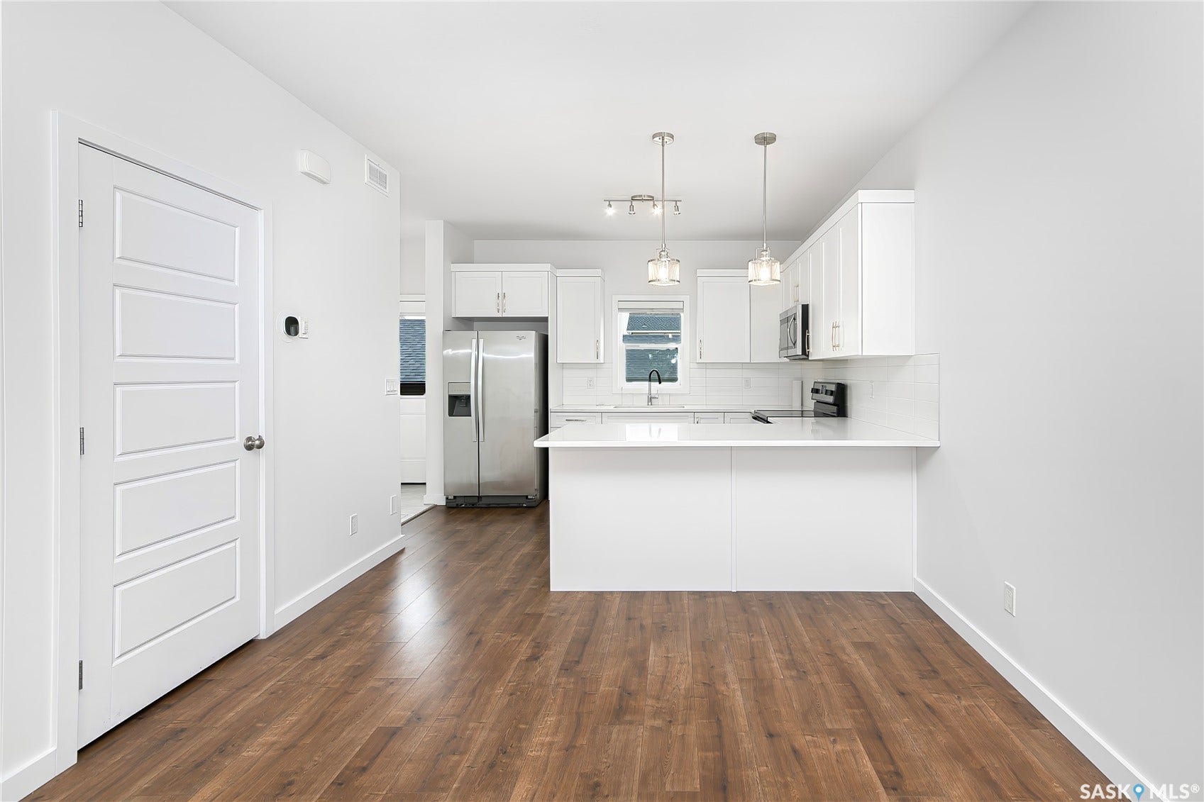 Kitchen with white cabinetry, stainless steel appliances, and a breakfast bar