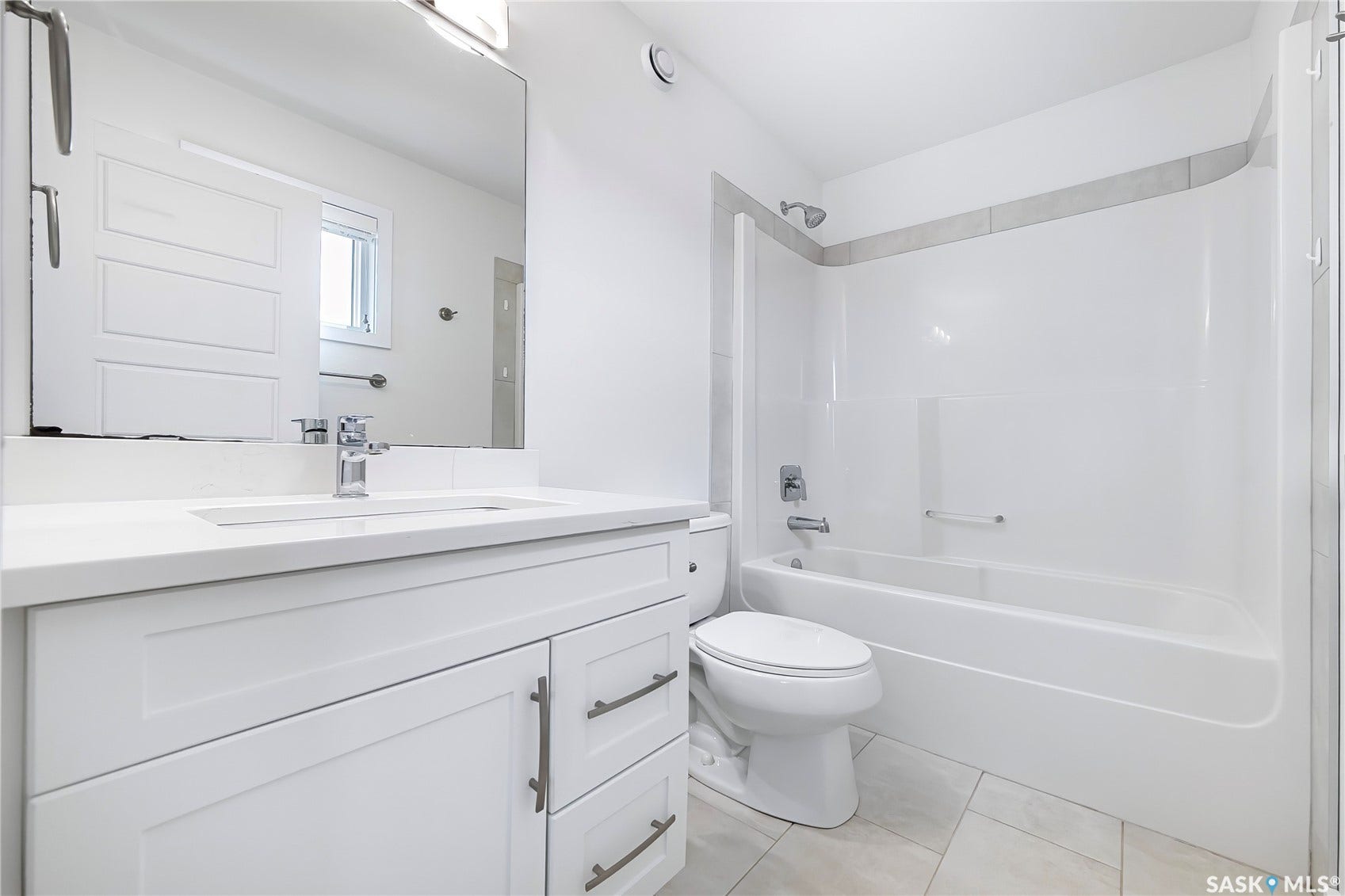 White vanity with integrated sink, chrome faucet, and rectangular mirror