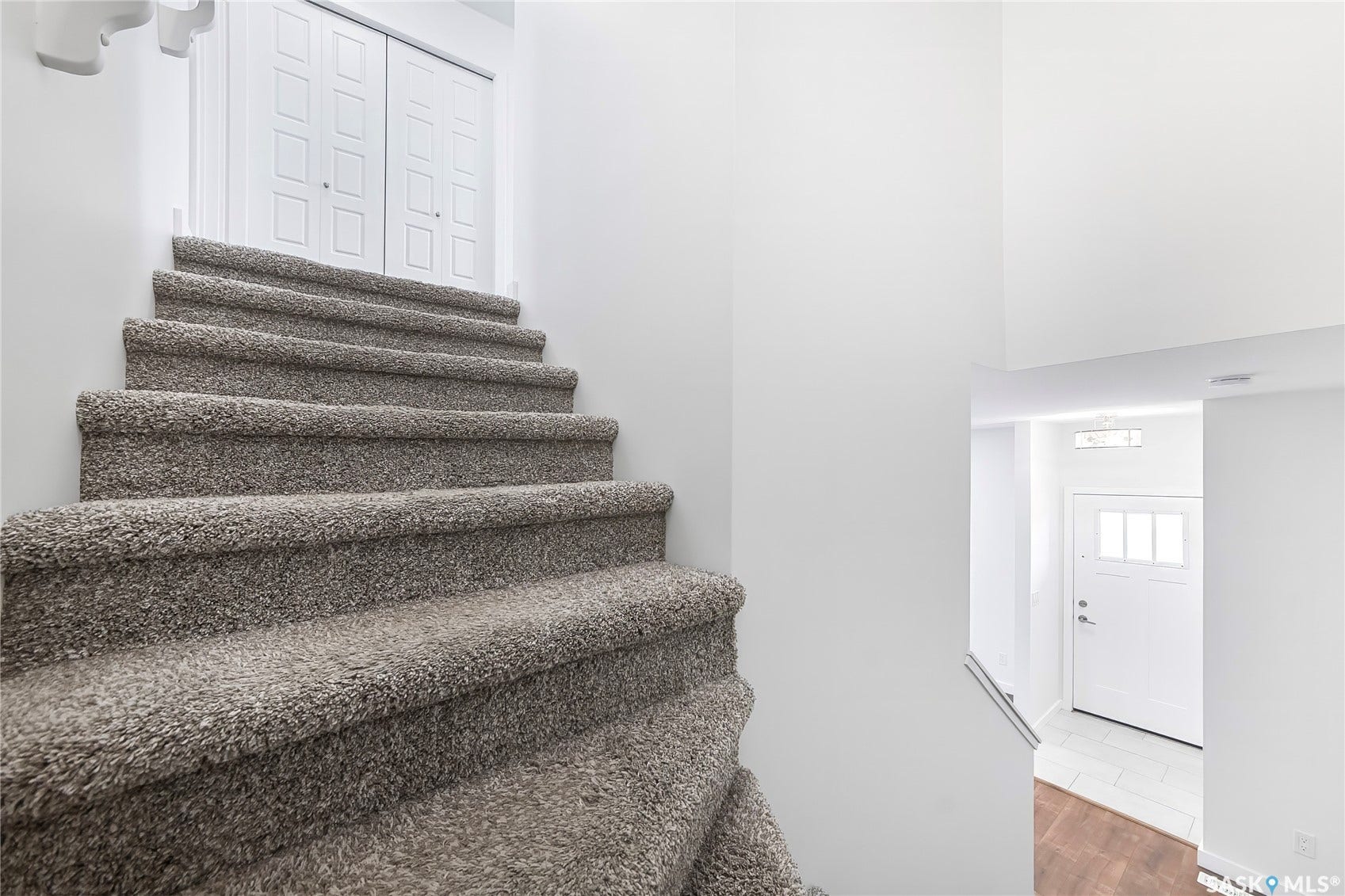 Carpeted staircase with white bi-fold doors