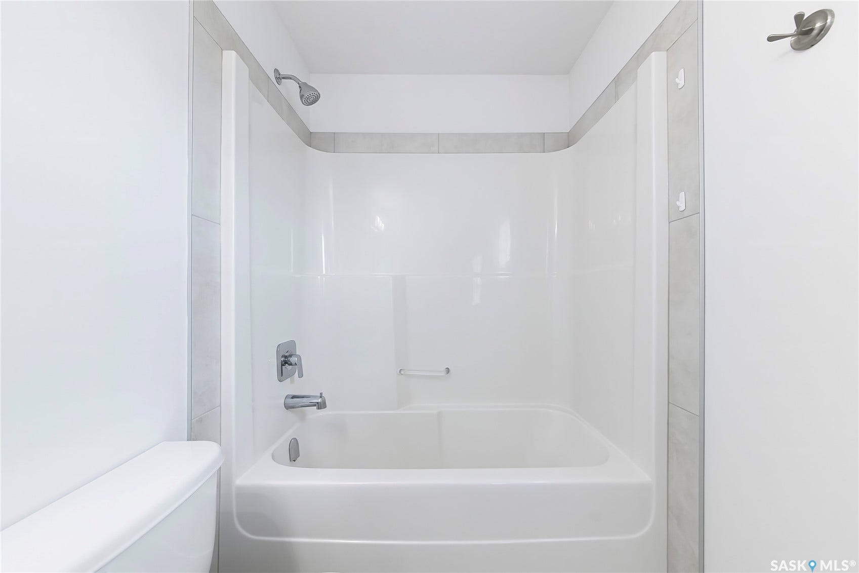 White fiberglass tub and shower combination with chrome fixtures