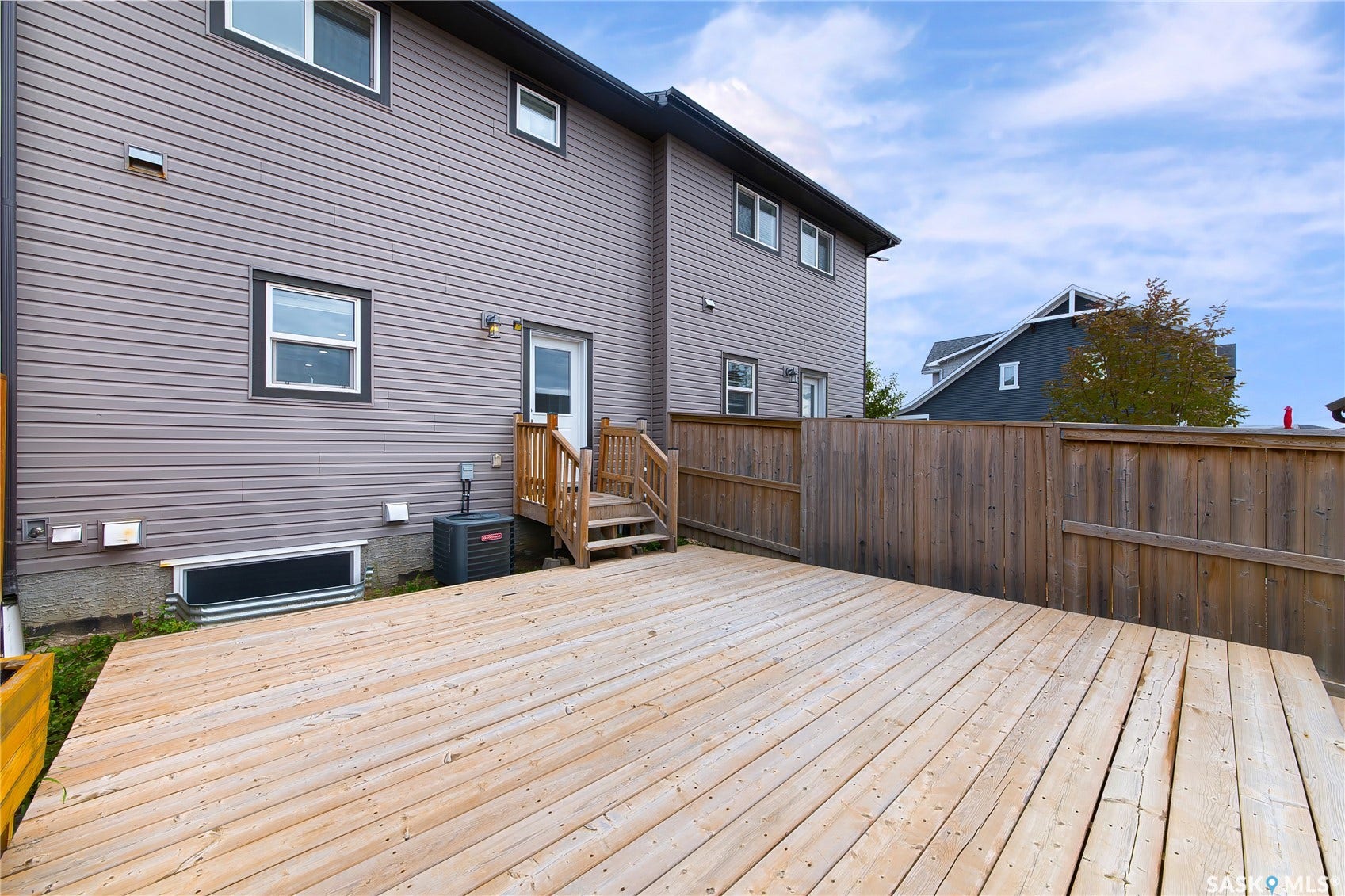 Spacious wood deck with a privacy fence