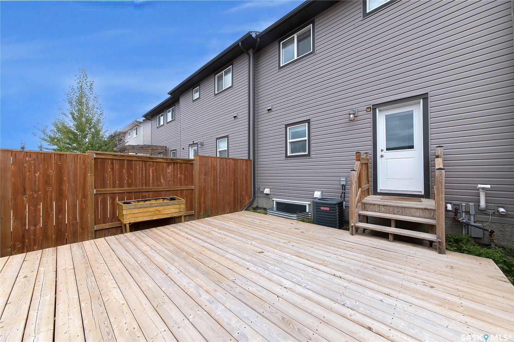 Expansive wooden deck, privacy fencing, and exterior siding