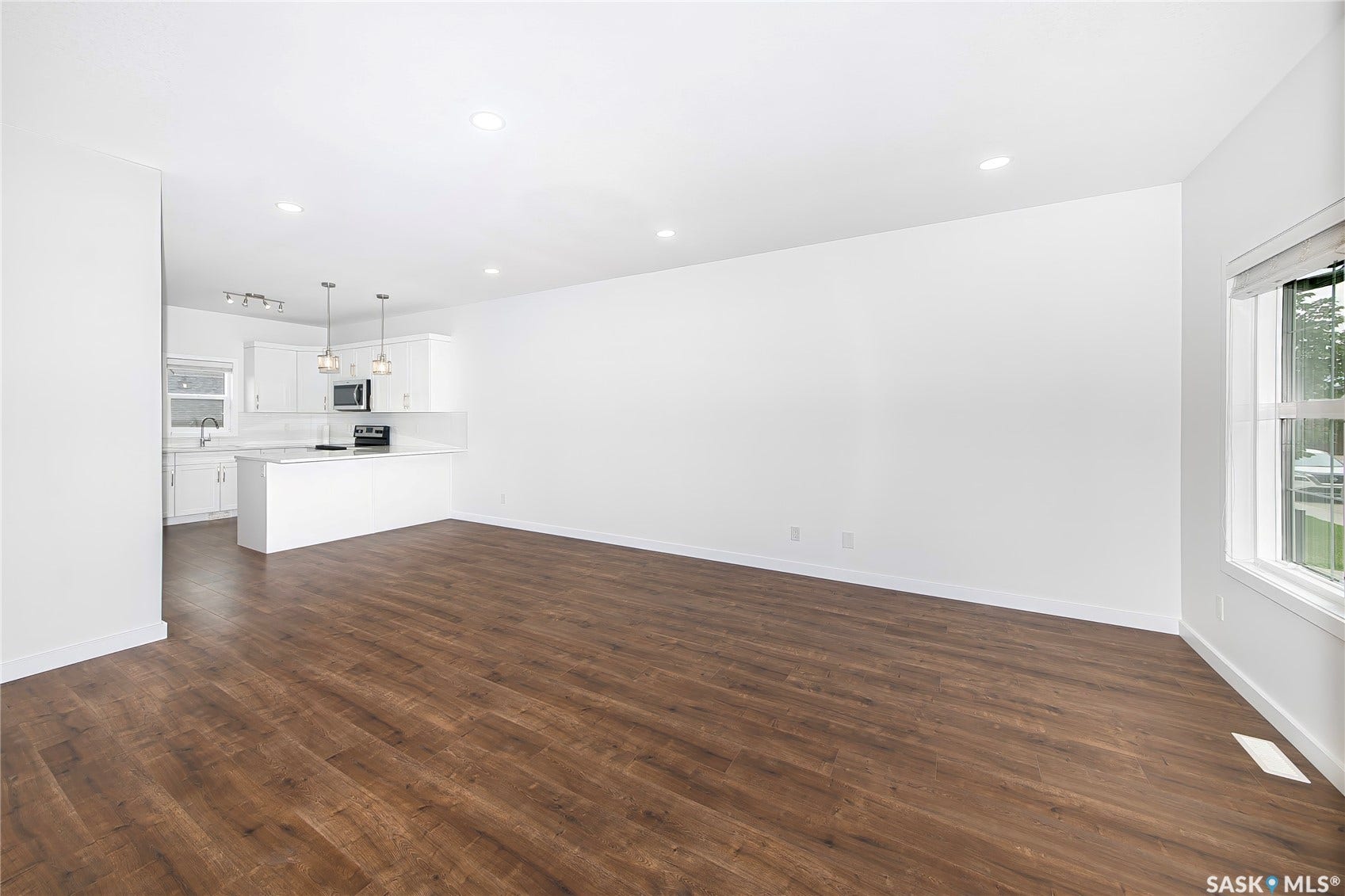 Open-concept layout with wood-finish flooring, recessed lighting, and a kitchen island