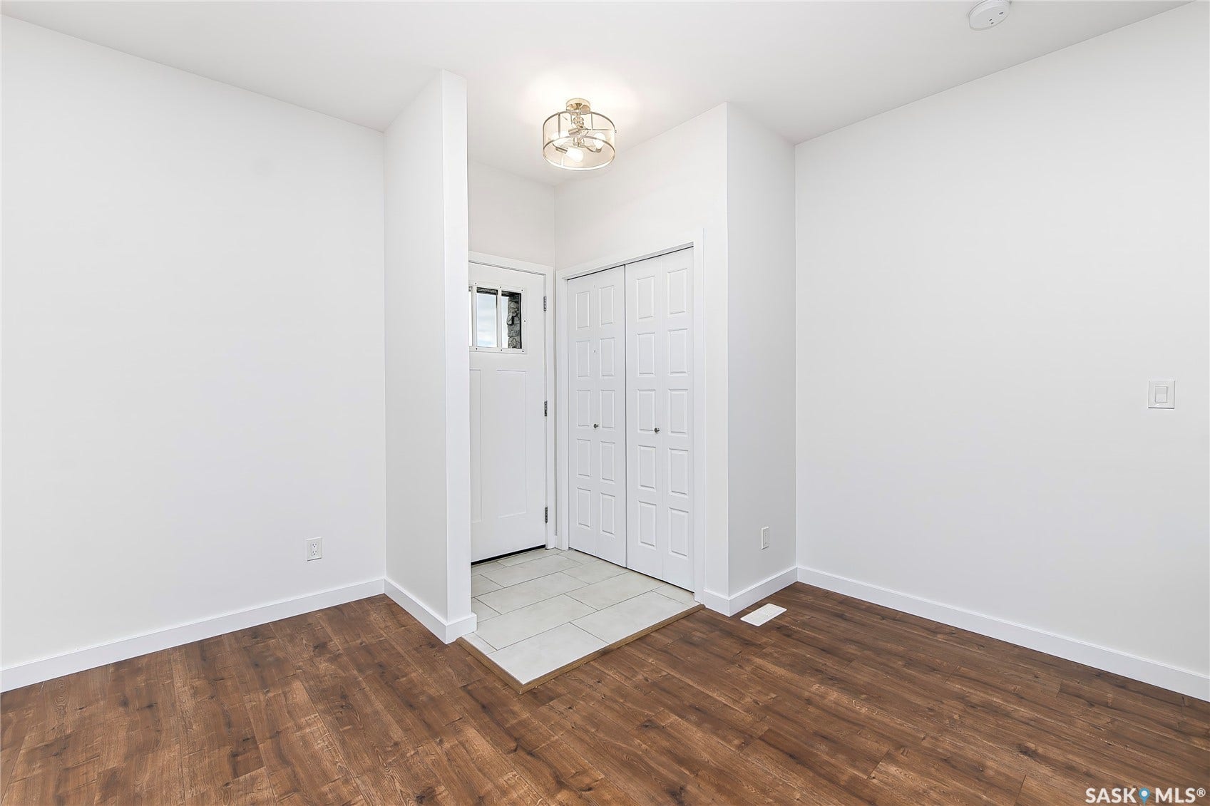 Foyer with wood-finish flooring, white walls, and a contemporary ceiling fixture