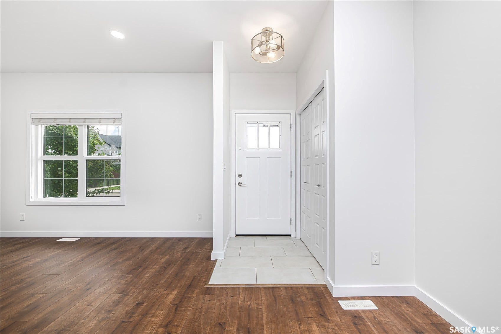 Entryway featuring tile flooring, a white paneled door with glass inserts, and a semi-flush mount light fixture