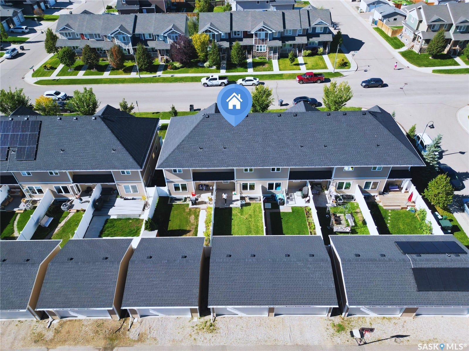 Rear-facing townhome with private backyard, individual patios, and direct access to detached garage structures