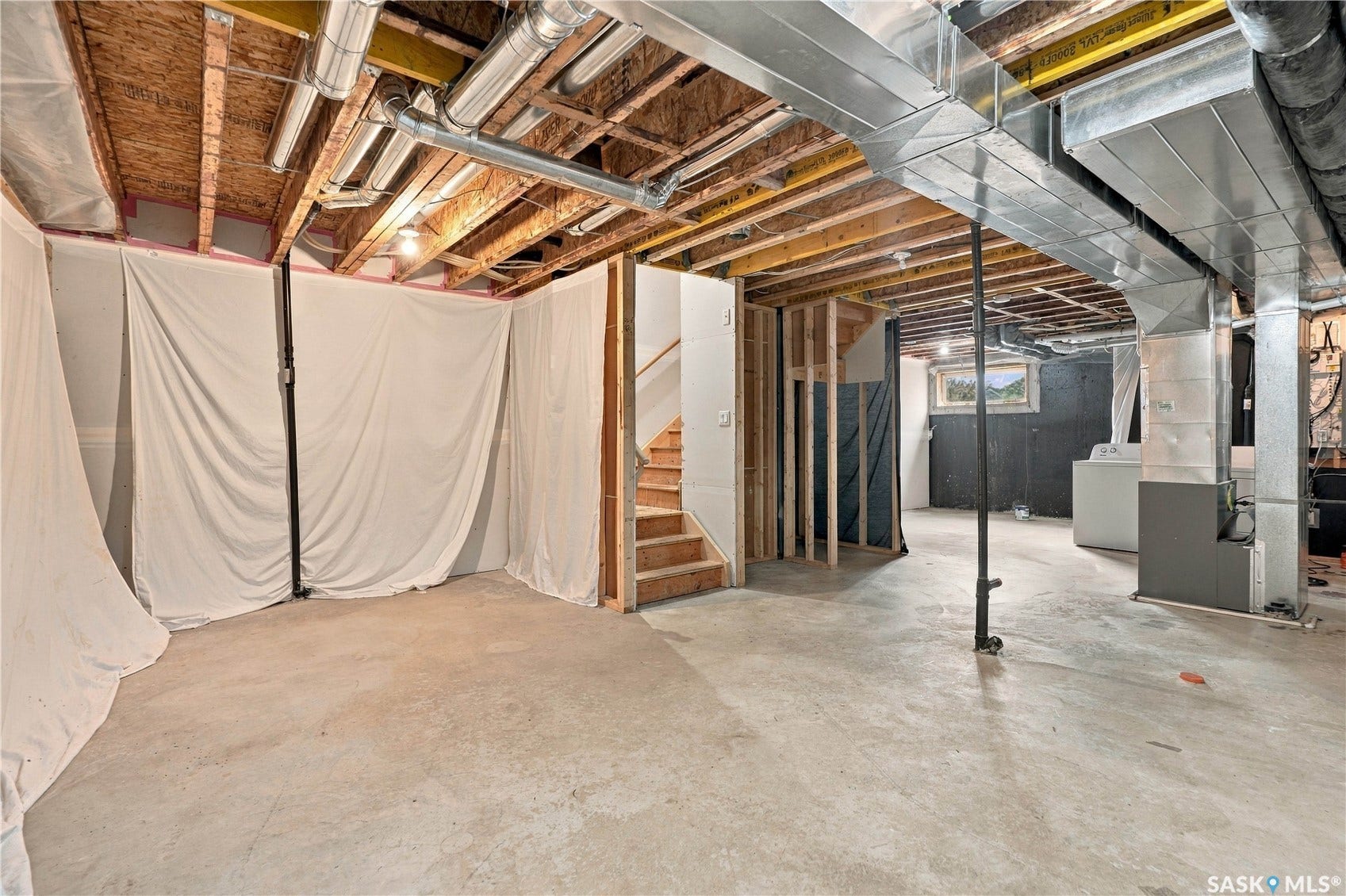 Unfinished basement featuring exposed wood joists, concrete flooring, and visible ductwork