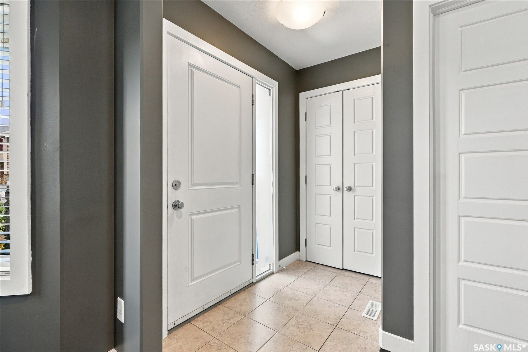 Entryway featuring tile flooring, a white paneled door, bi-fold closet doors, and recessed lighting