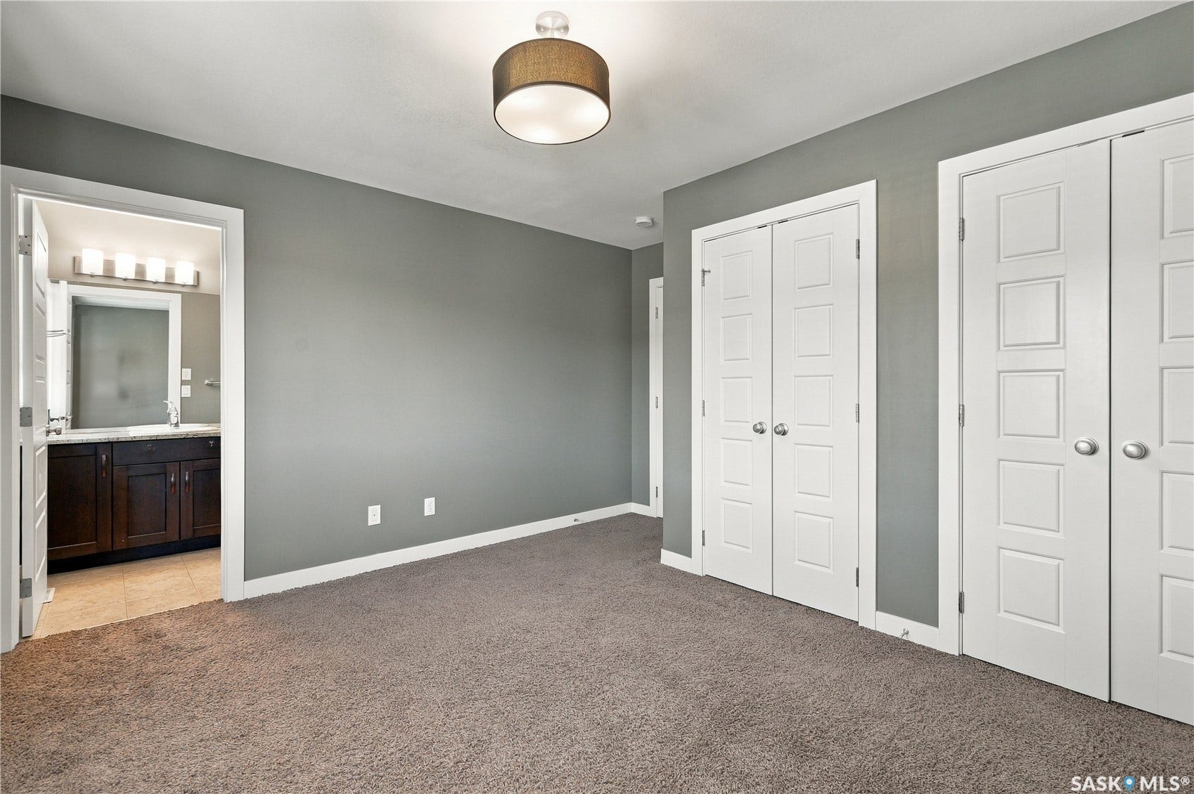 Plush carpet flooring, recessed ceiling lighting, and multiple paneled doors