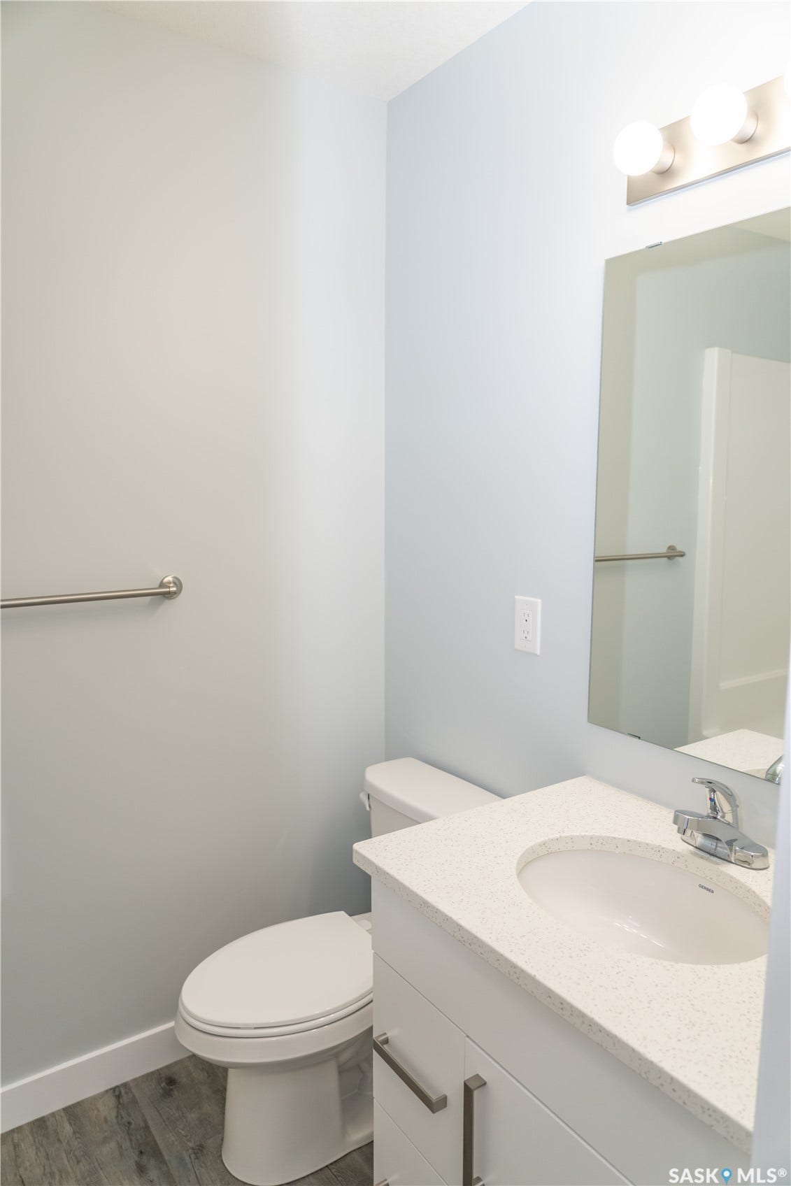 306 Stehwien Street, Saskatoon SK S7W 1P3 Bathroom with wood-type flooring, toilet, and large vanity