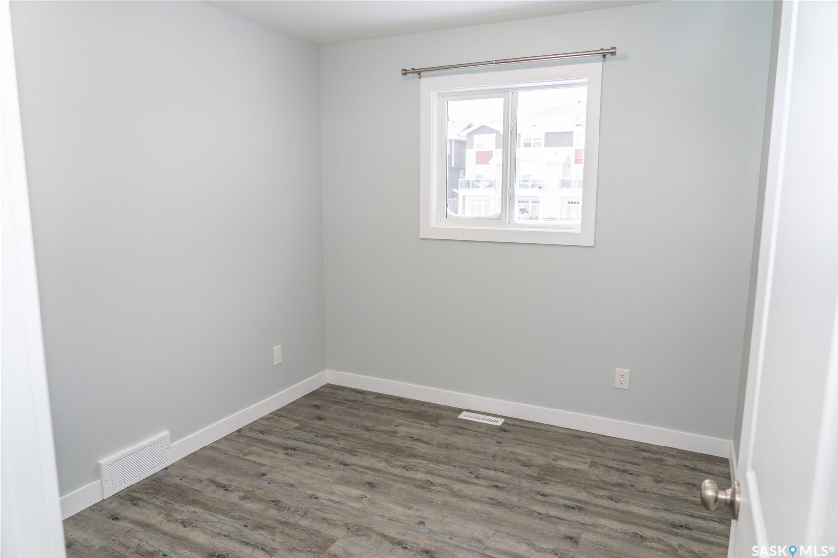 306 Stehwien Street, Saskatoon SK S7W 1P3 Spare room with dark hardwood / wood-style floors