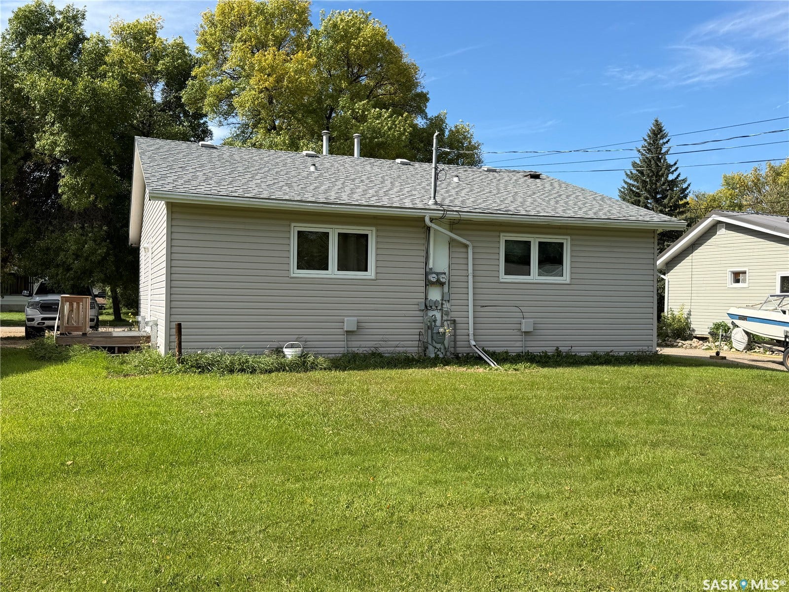 Exterior featuring light-colored siding, white-framed windows, and a gray shingle roof