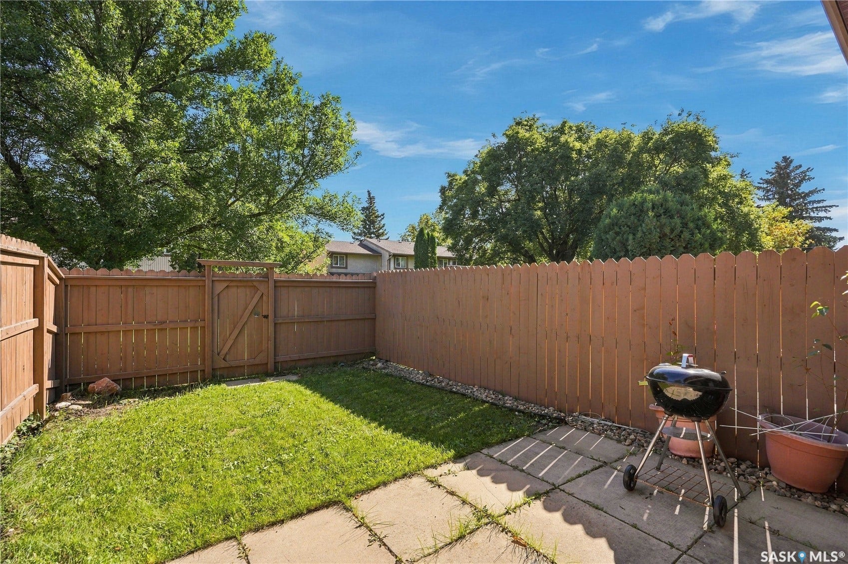 Fenced backyard featuring a grassy area and a patio with concrete pavers