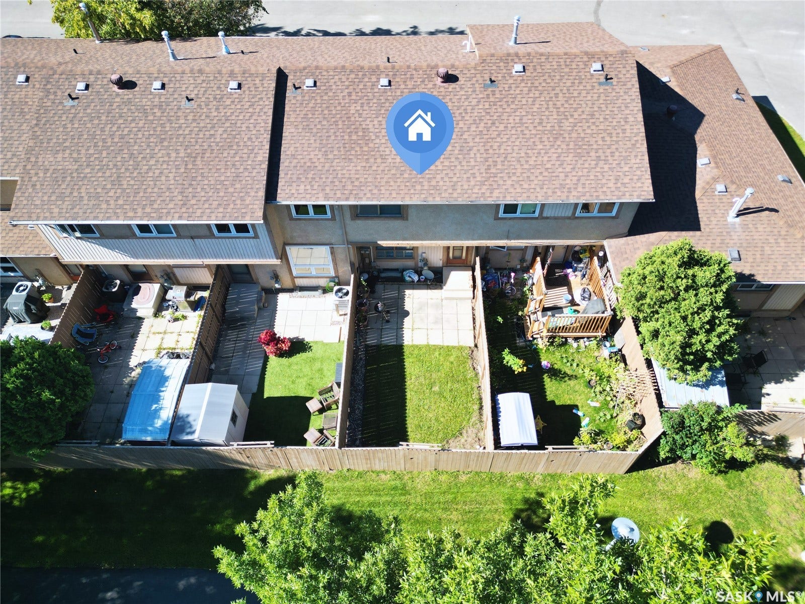 Backyard featuring a privacy fence, paved patio area, and mature trees
