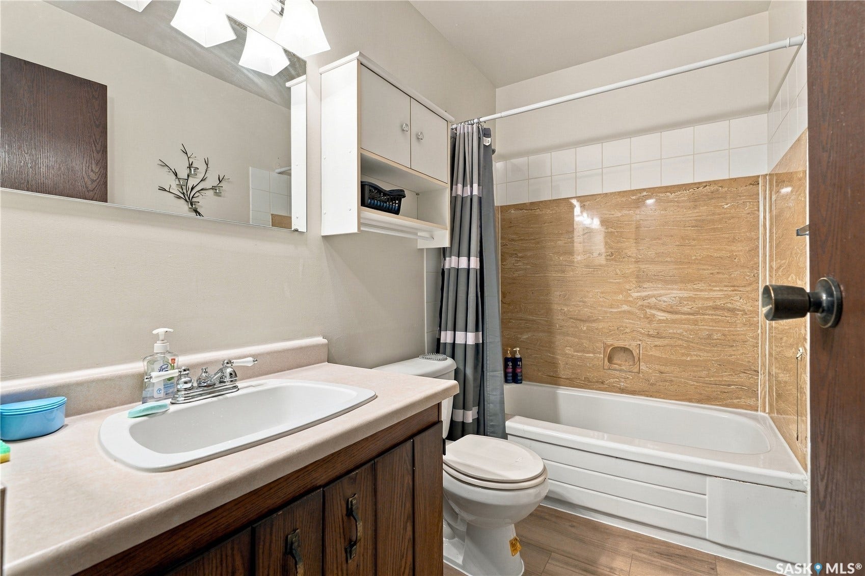 Bathroom featuring a built-in vanity with an integrated sink, wall-mounted mirror, and overhead lighting