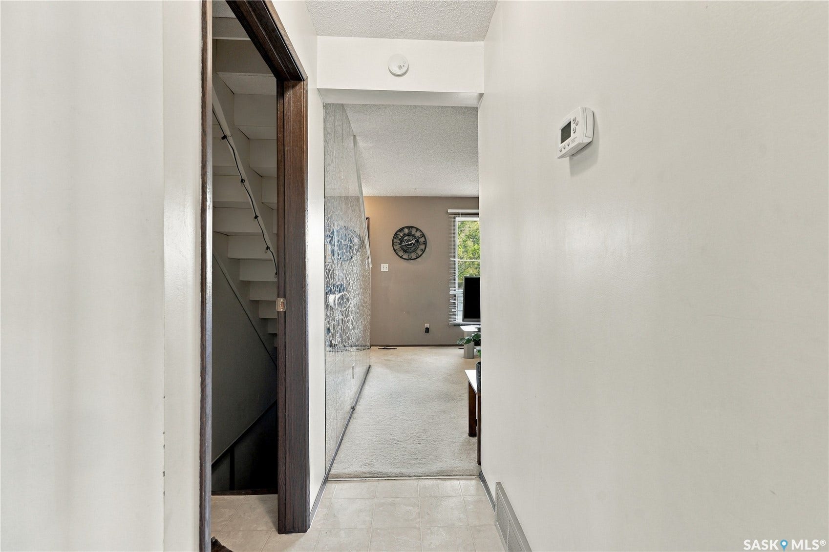 Hallway featuring light-colored walls and a wall-mounted thermostat
