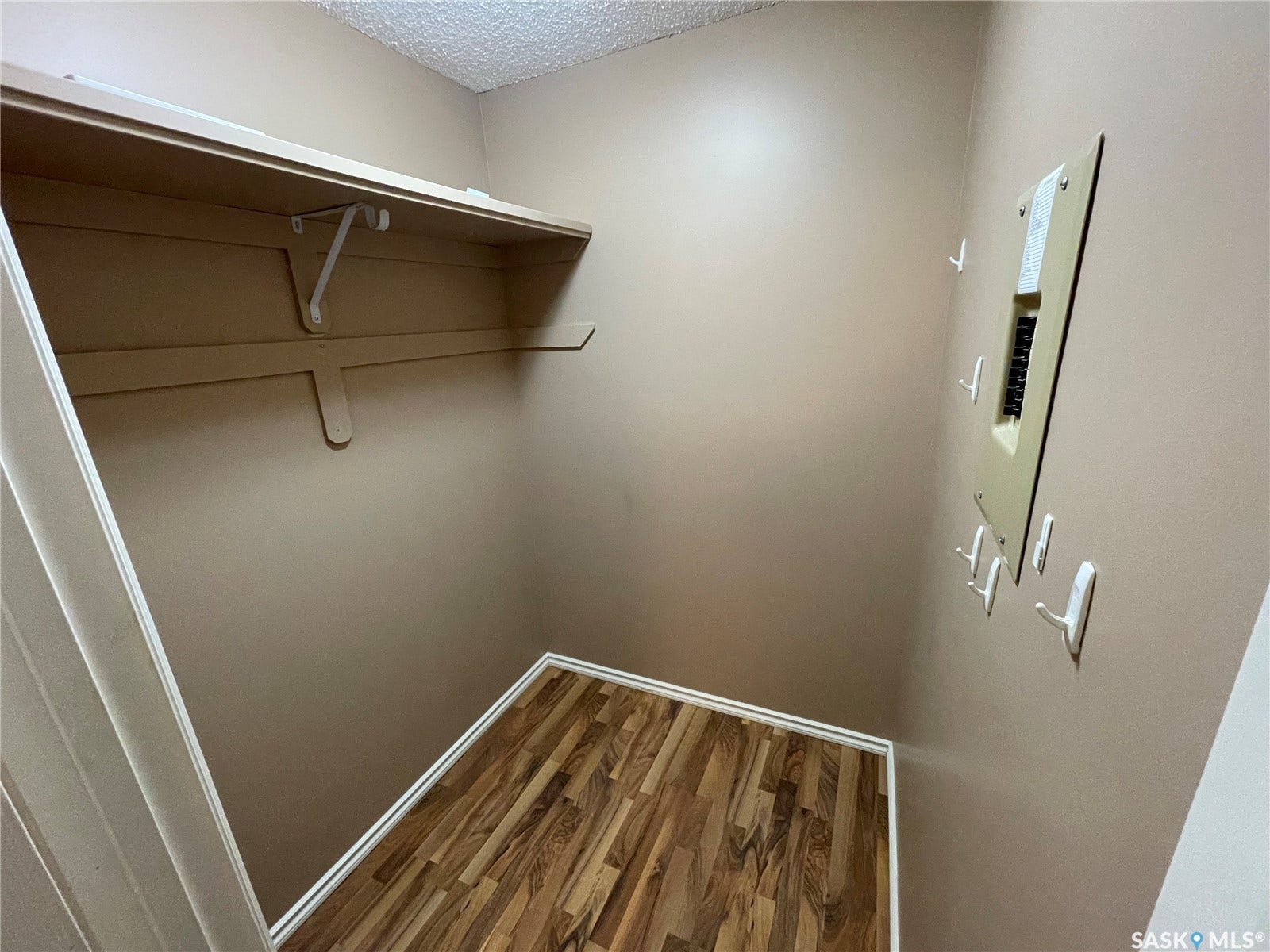 Built-in shelving with supports, wood-finish flooring, and neutral wall tones