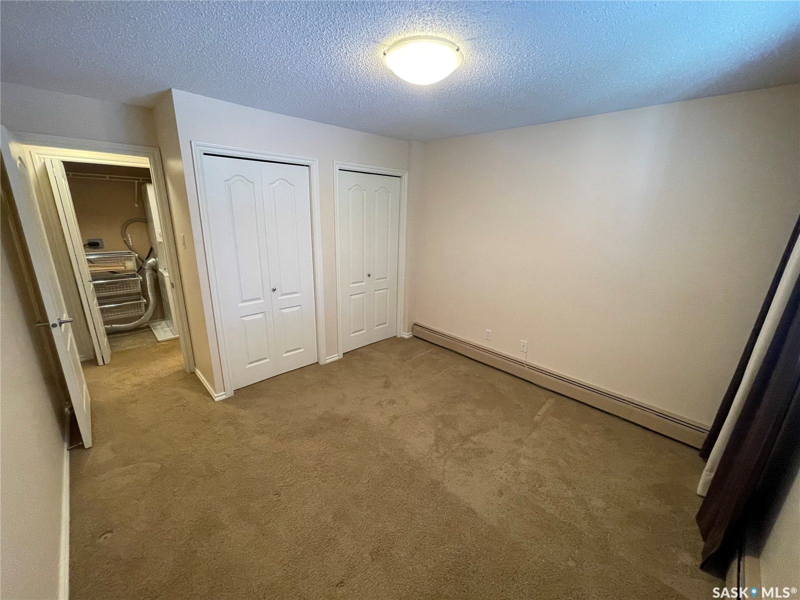 Neutral tone wall paint,  two bi-fold closet doors, wall-to-wall carpeting.