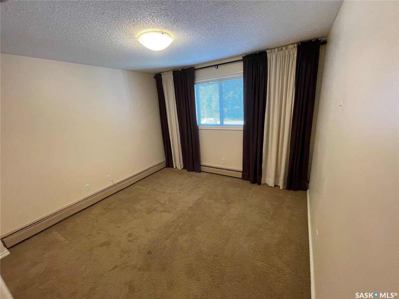 Carpeted flooring, window with curtain rods.