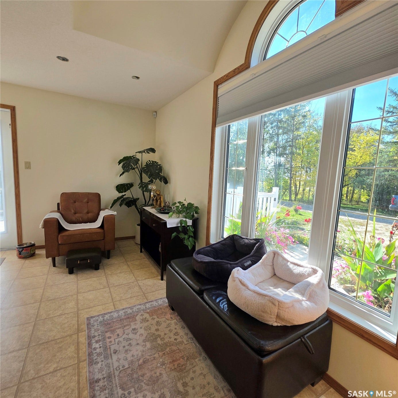 Arched transom window with cellular shade, tile flooring, recessed lighting, and wall-mounted light fixture