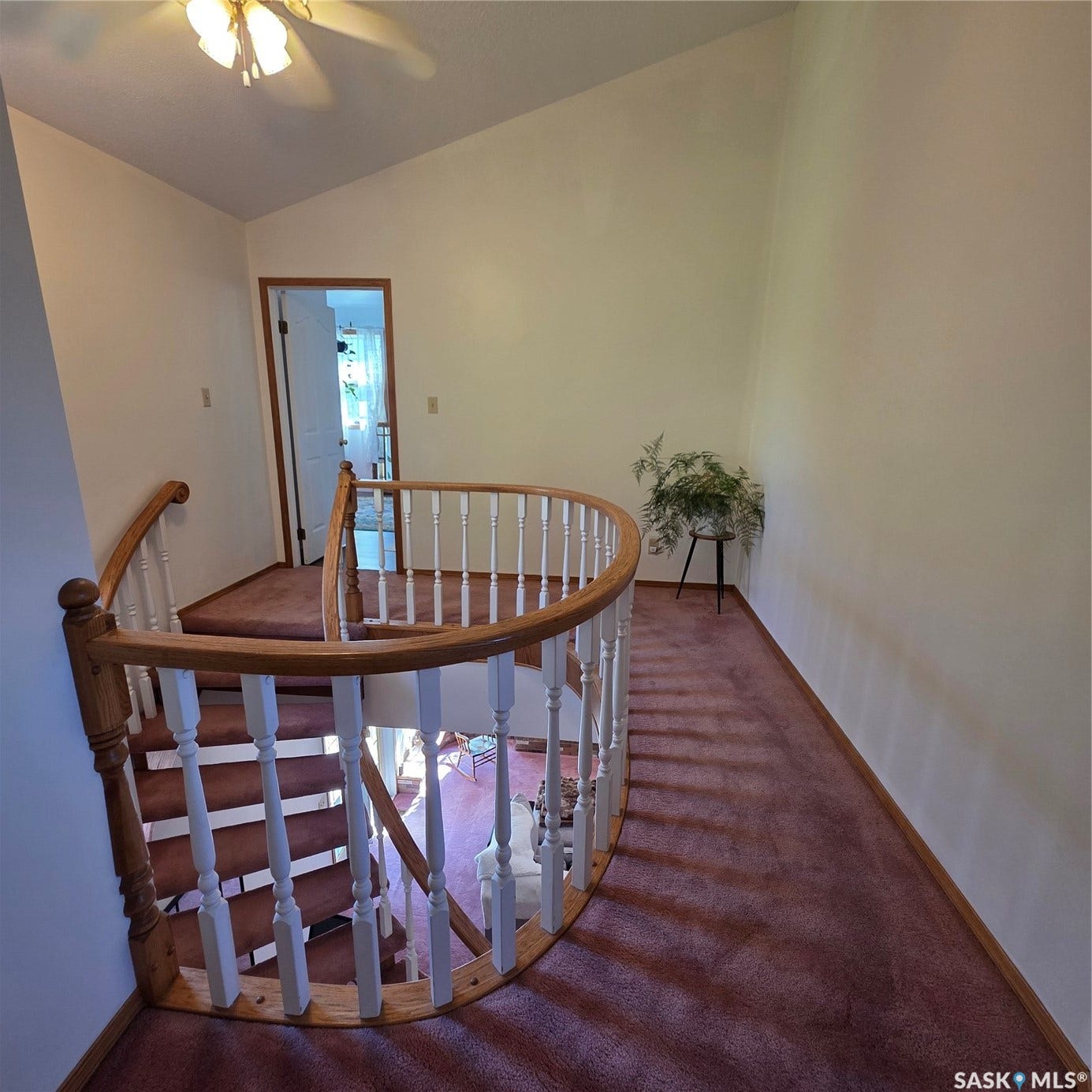 Curved staircase with wood-finish handrail and white balusters