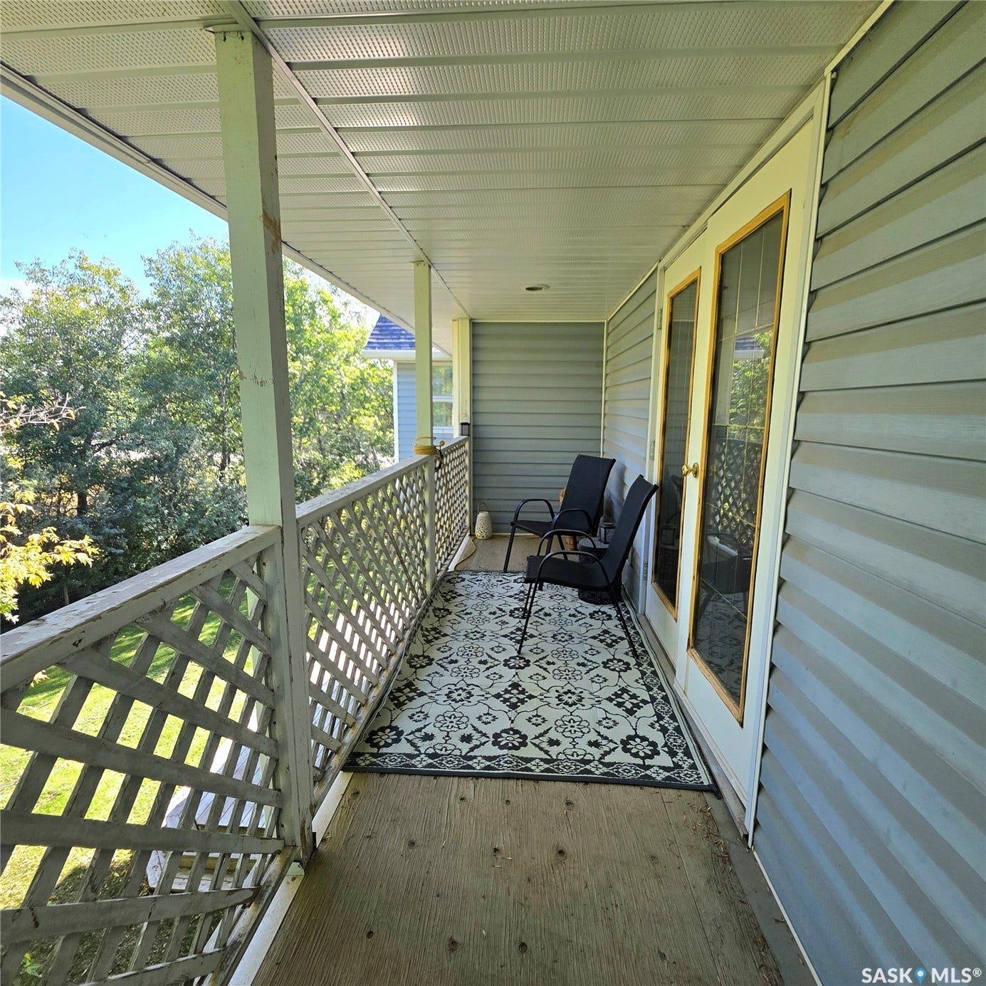 Covered balcony featuring wood flooring and a lattice railing