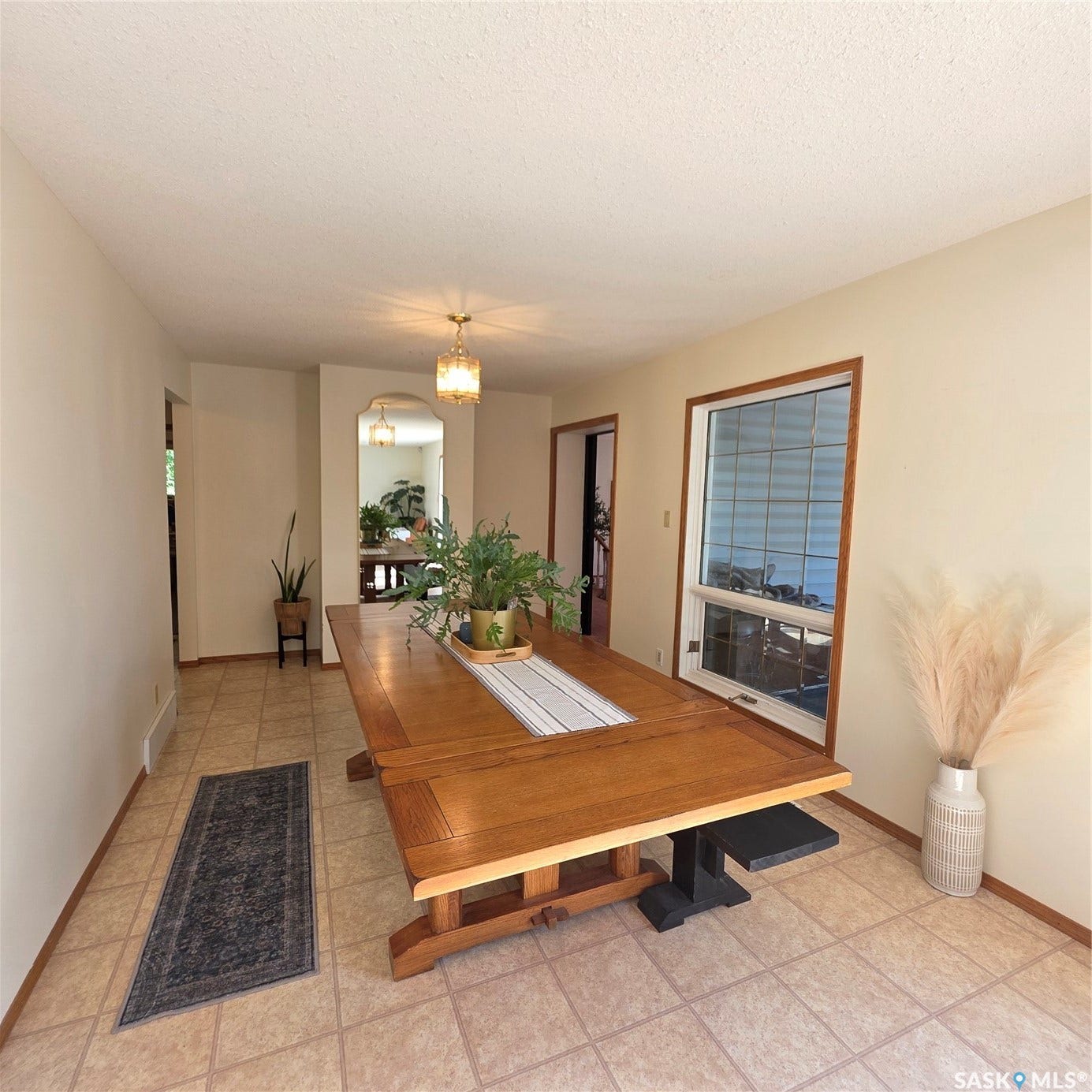 Recessed window with wood trim, neutral tone walls, tile flooring, and overhead lighting