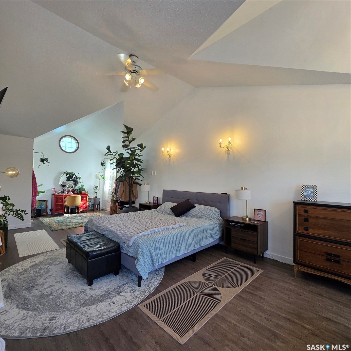 Vaulted ceilings, wood-finish flooring, ceiling fan, and wall-mounted sconces