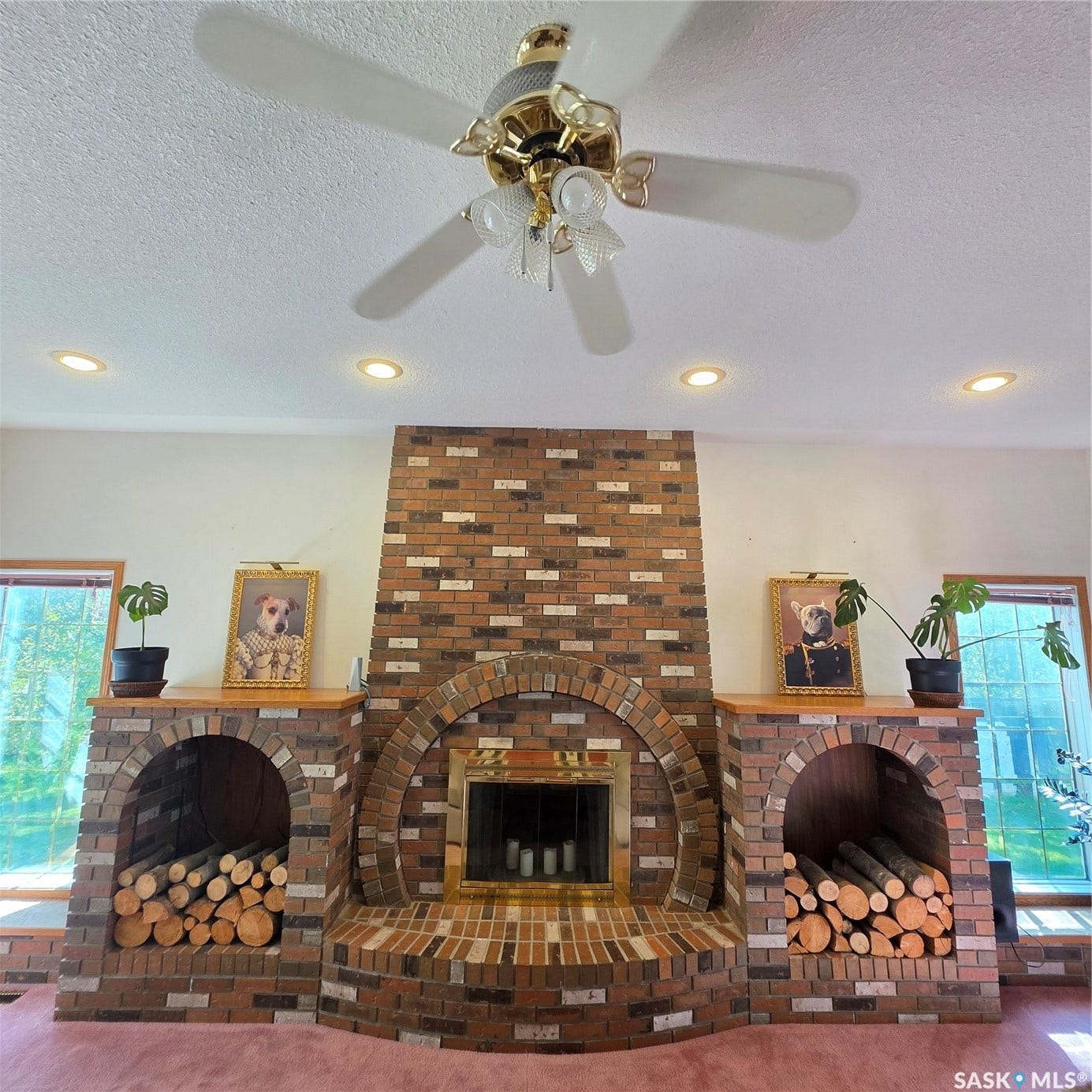 Floor-to-ceiling brick fireplace with an arched firebox and brass-toned trim