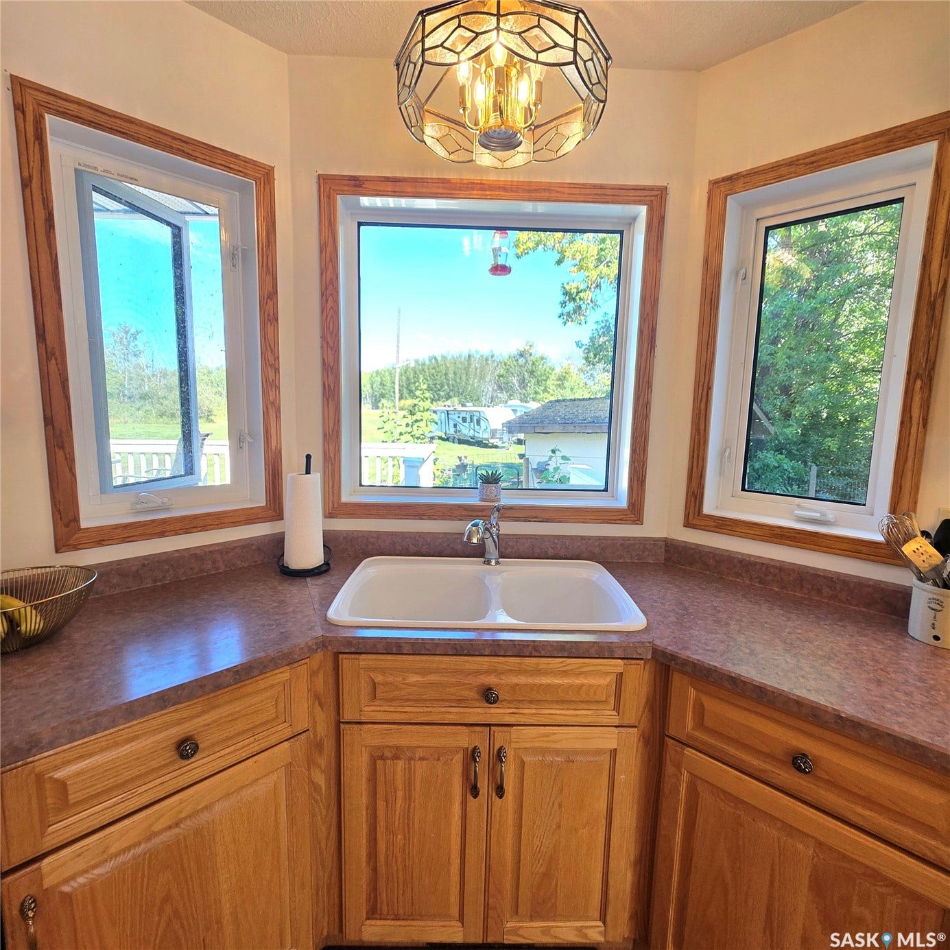 Corner sink with a dual basin and stainless steel faucet, set into a laminate countertop