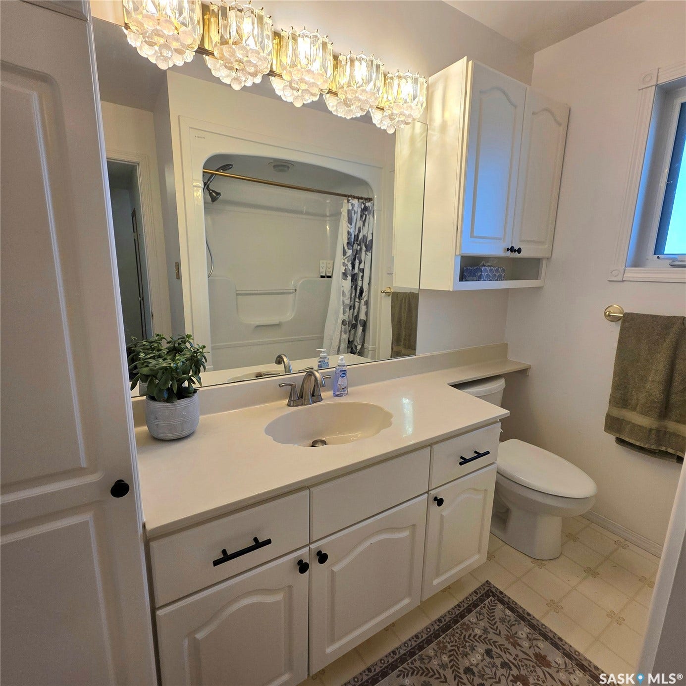 Bathroom featuring a vanity with an integrated sink, ample counter space, built-in cabinetry, and a combination shower/tub