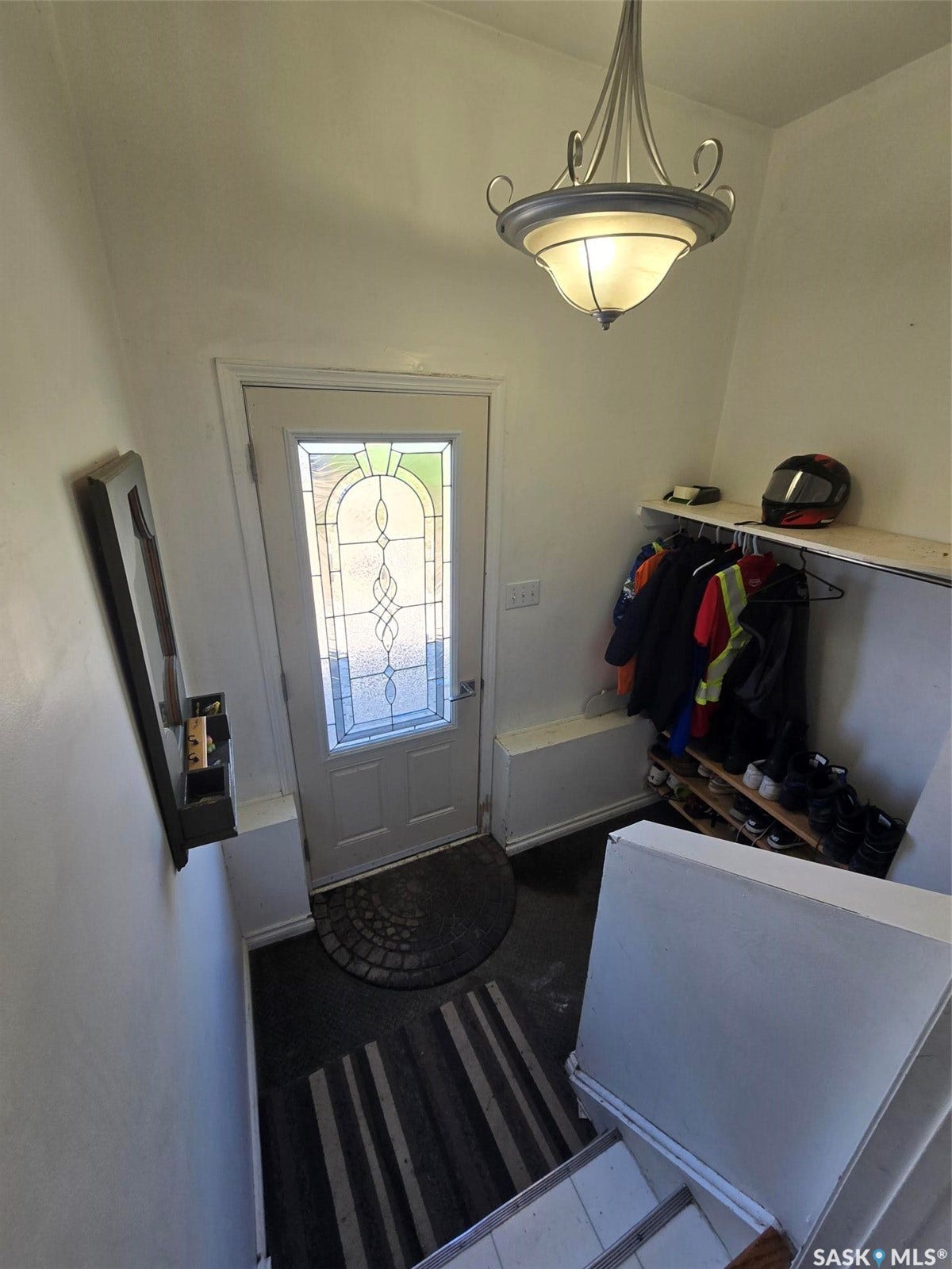 Entryway featuring a decorative glass-paneled door, overhead semi-flush mount lighting, and built-in shelving