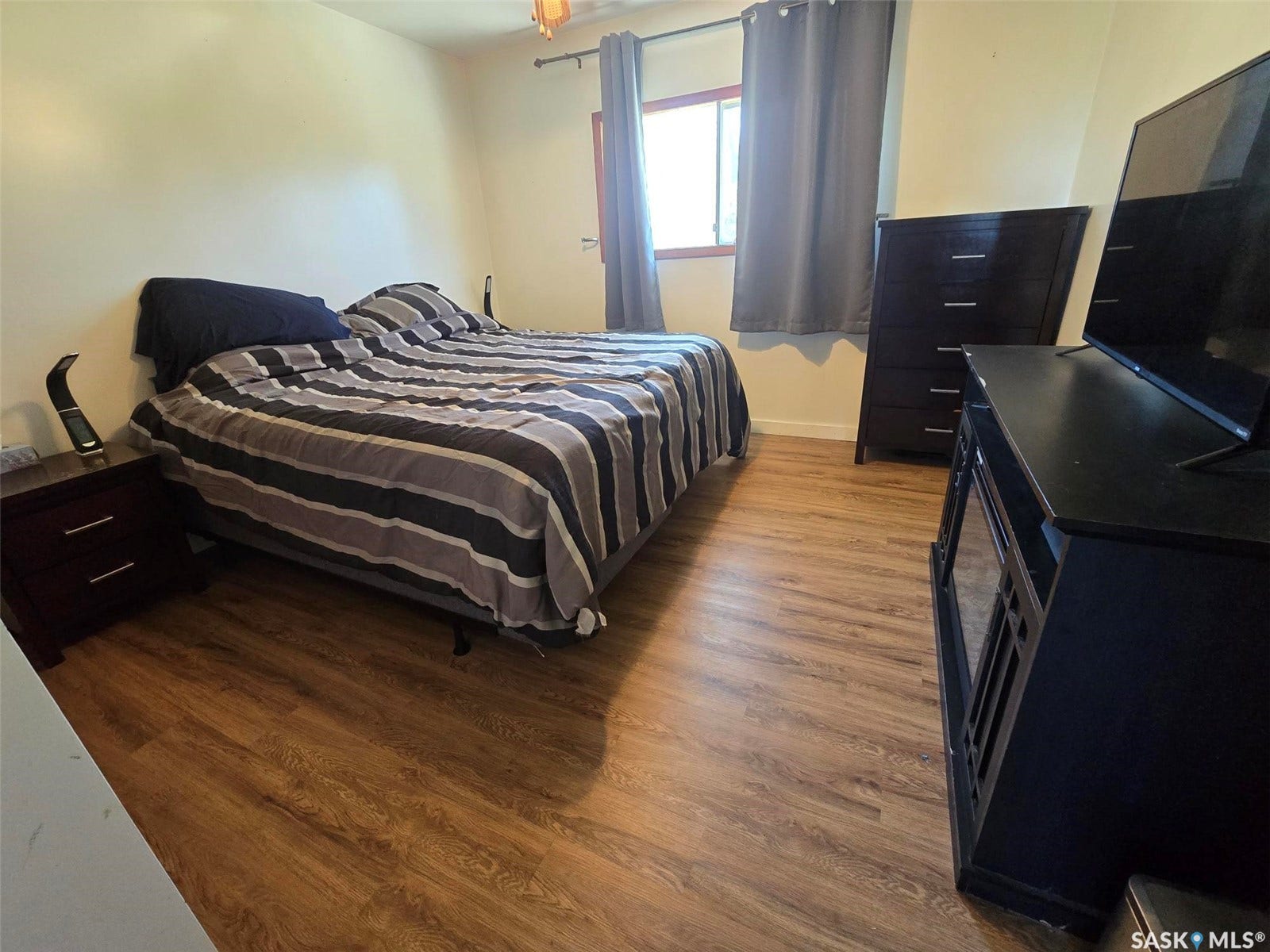 Wood-finish flooring throughout, complemented by light-toned wall finishes and a window with trim