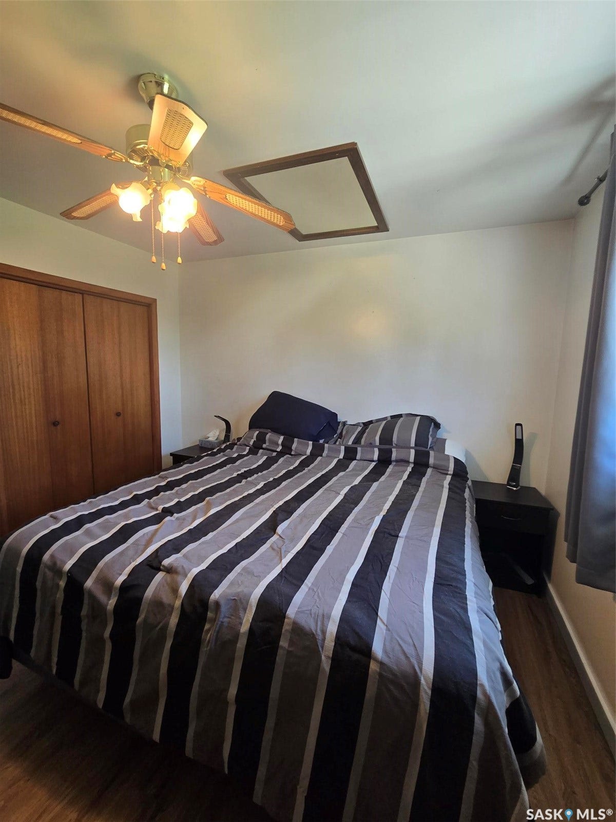 Ceiling fan with integrated lighting, wood-finish flooring, and built-in closet with double doors