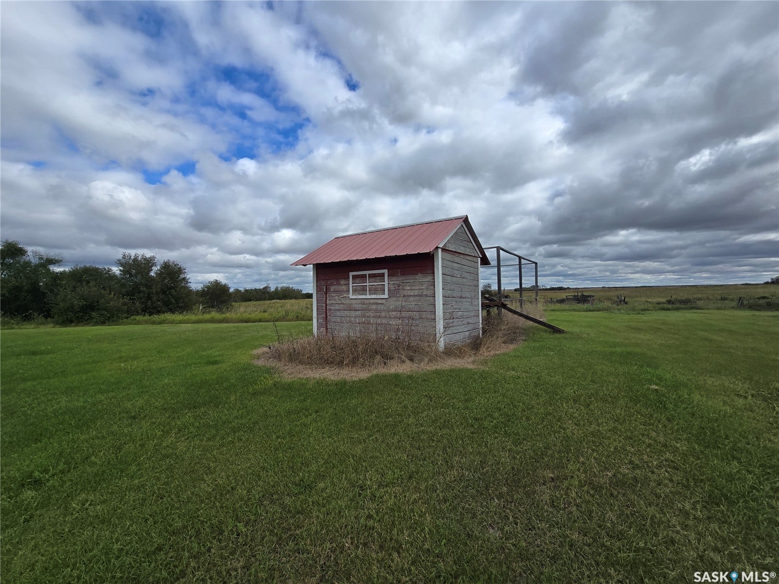 Outbuilding featuring a red metal roof and wood siding