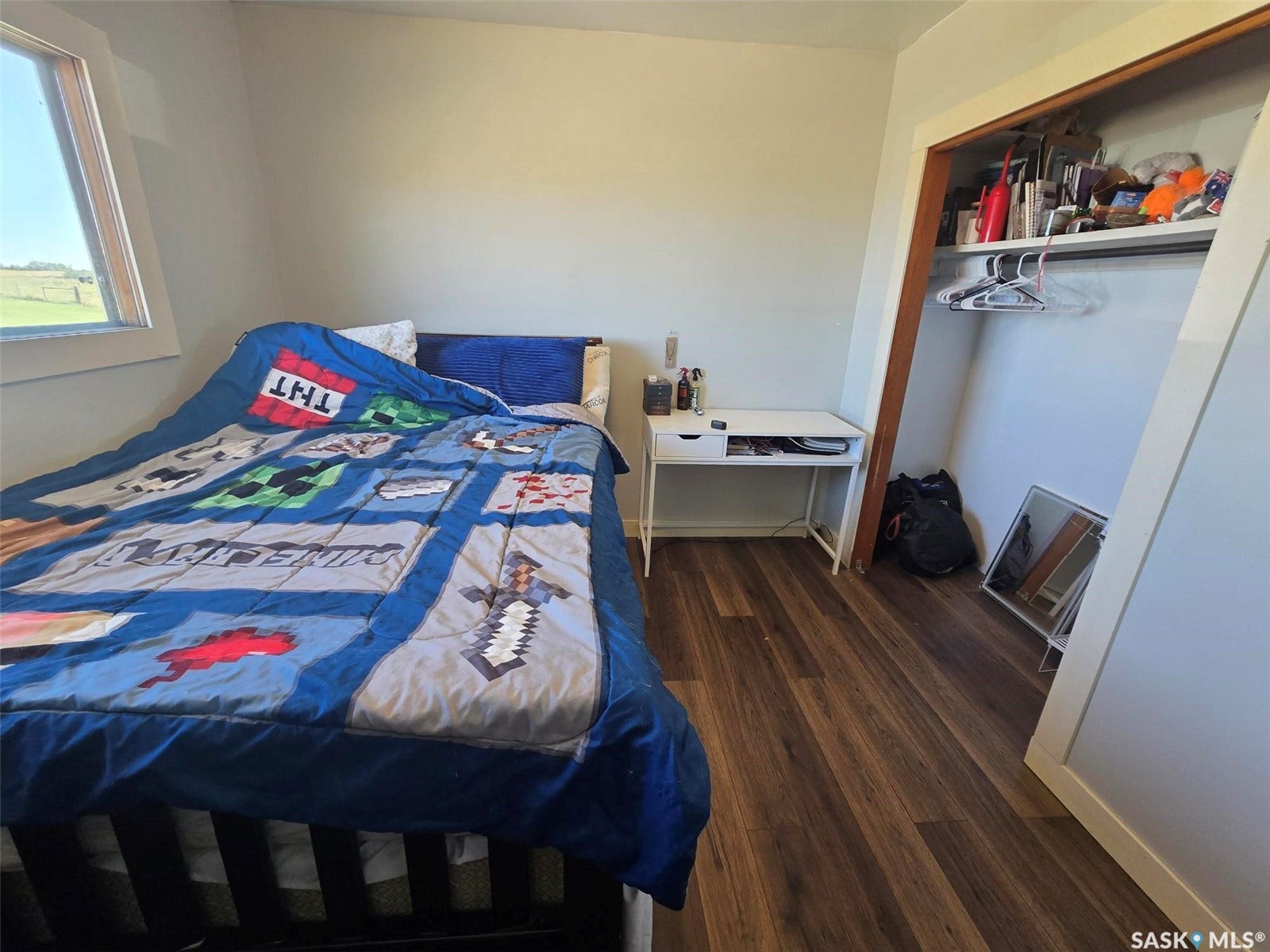 2ND BEDROOM - Hardwood-look flooring, light-toned walls, and an open closet space