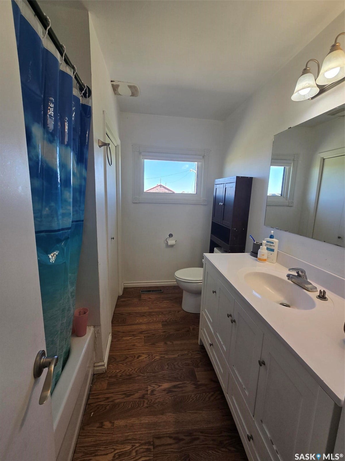 White vanity with ample cabinet storage, integrated sink, and brushed nickel faucet