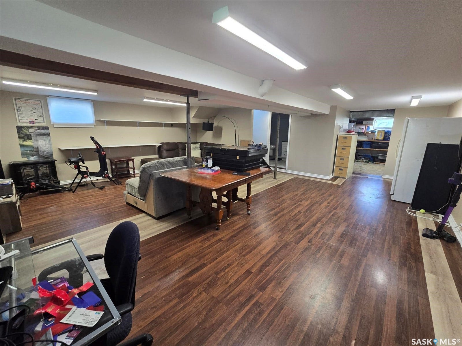 Spacious room featuring wood-finish flooring, recessed lighting, and a built-in shelving unit