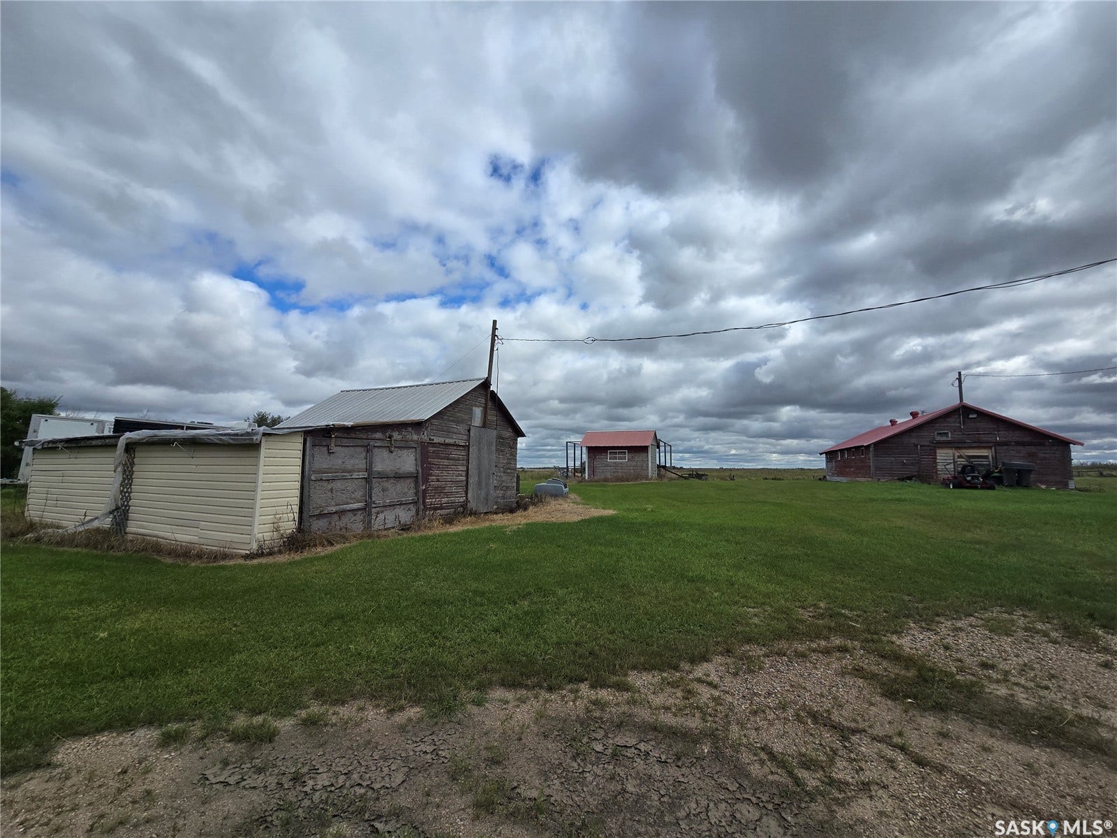 Expansive green space with multiple outbuildings featuring various rooflines and exterior finishes