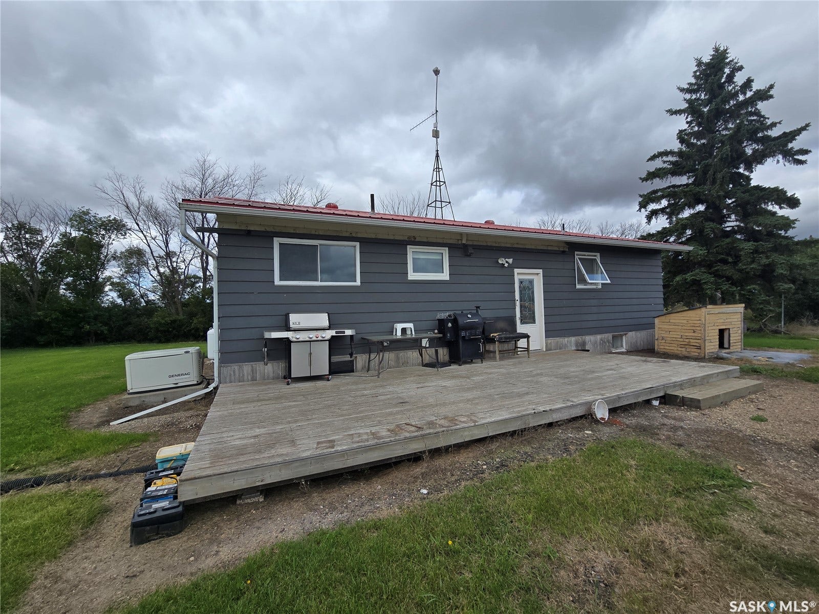 Expansive exterior decking with direct access to interior, featuring durable siding and a red-toned roof