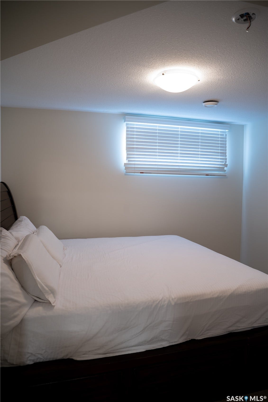 Recessed window with horizontal blinds, white ceiling, and surface-mounted light fixture