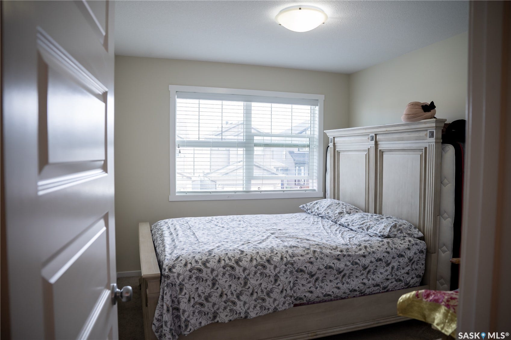 Recessed window with blinds, ceiling-mounted light fixture, and neutral wall tones