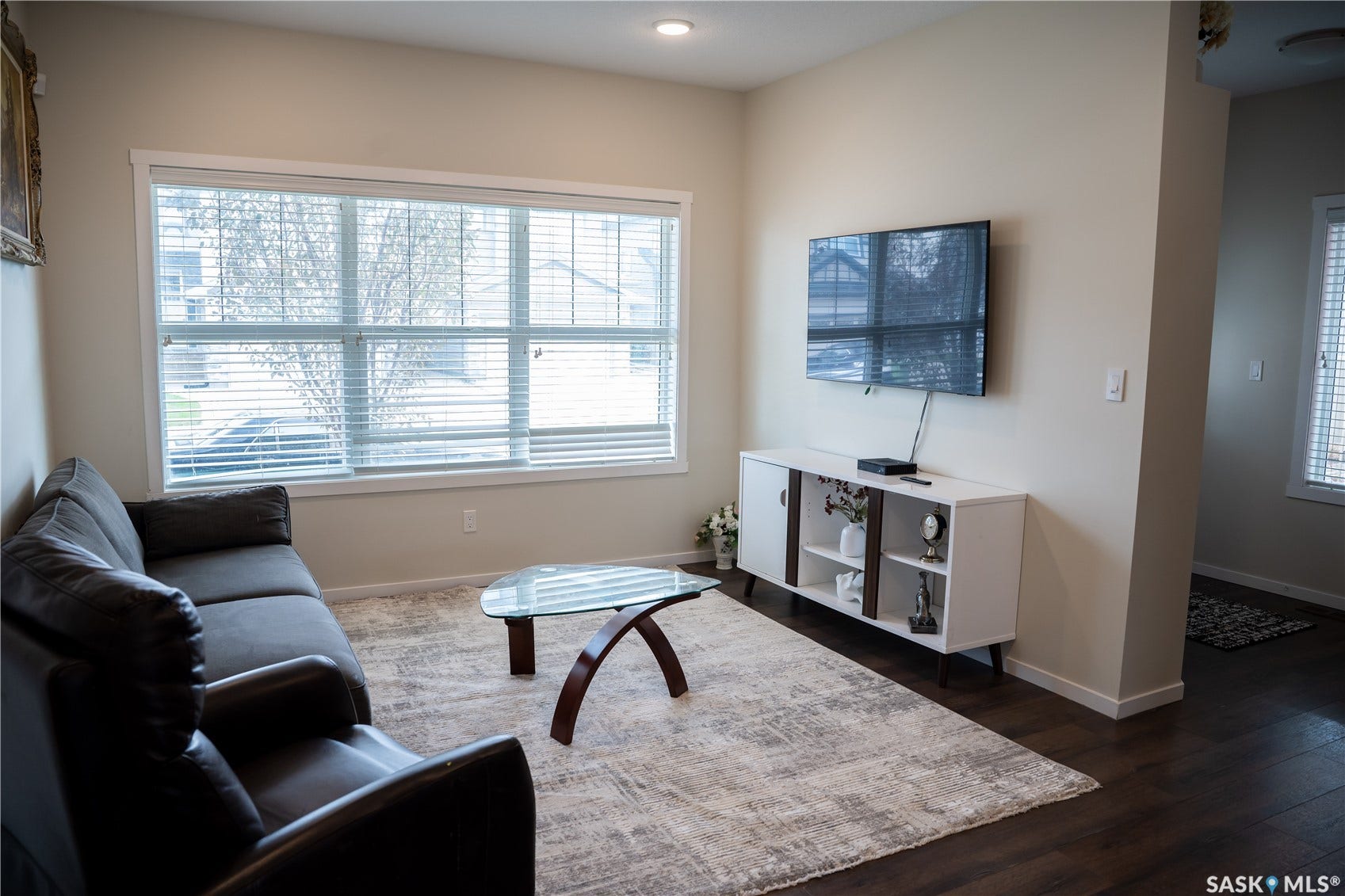 Recessed lighting, wood-finish flooring, and white window blinds