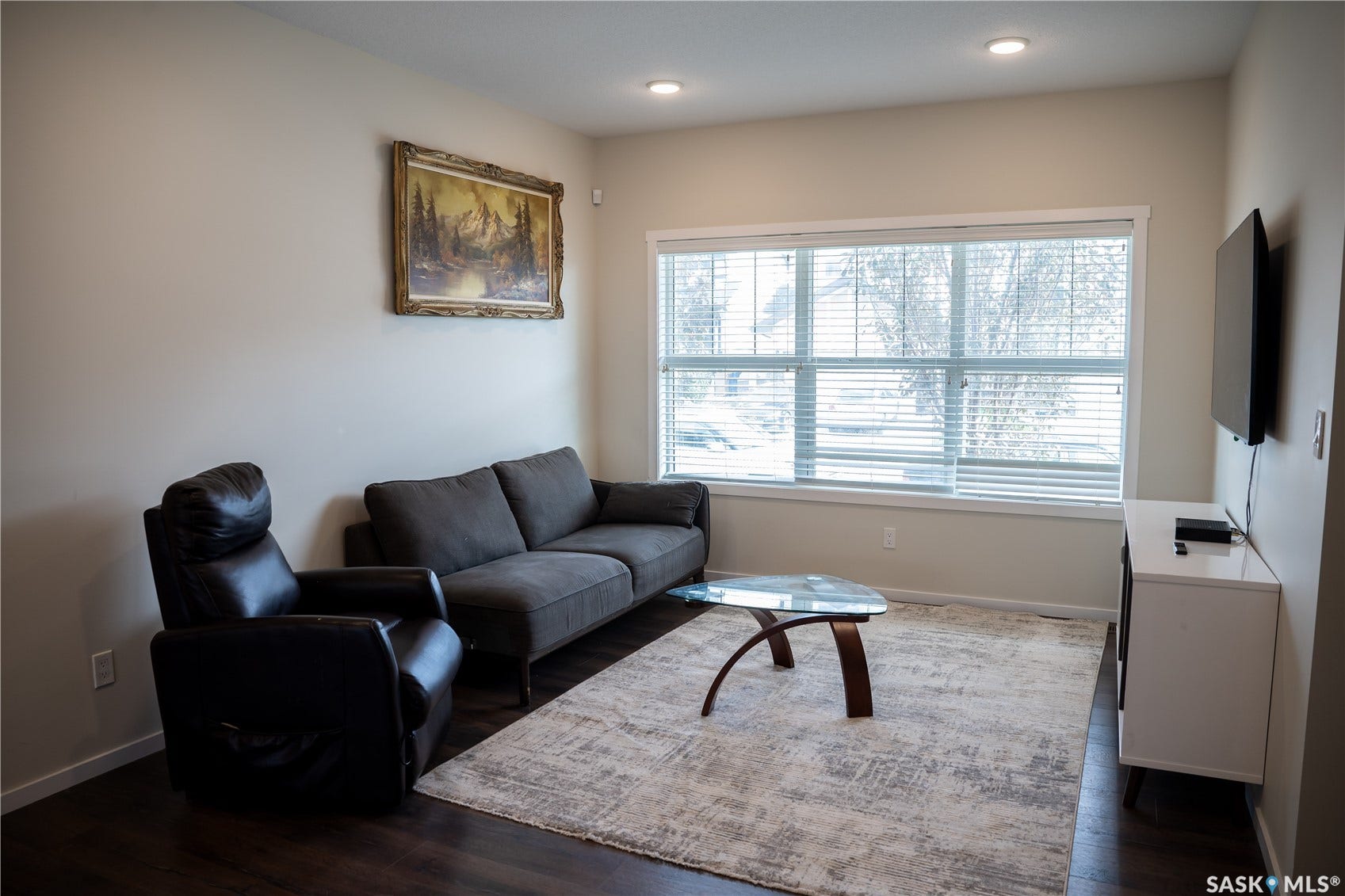 Recessed lighting, large window with blinds, wood-finish flooring, and light-toned walls