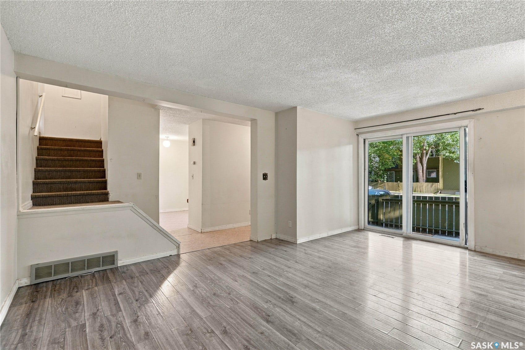 Wood-finish flooring throughout, with a sliding glass door providing outdoor access to a deck