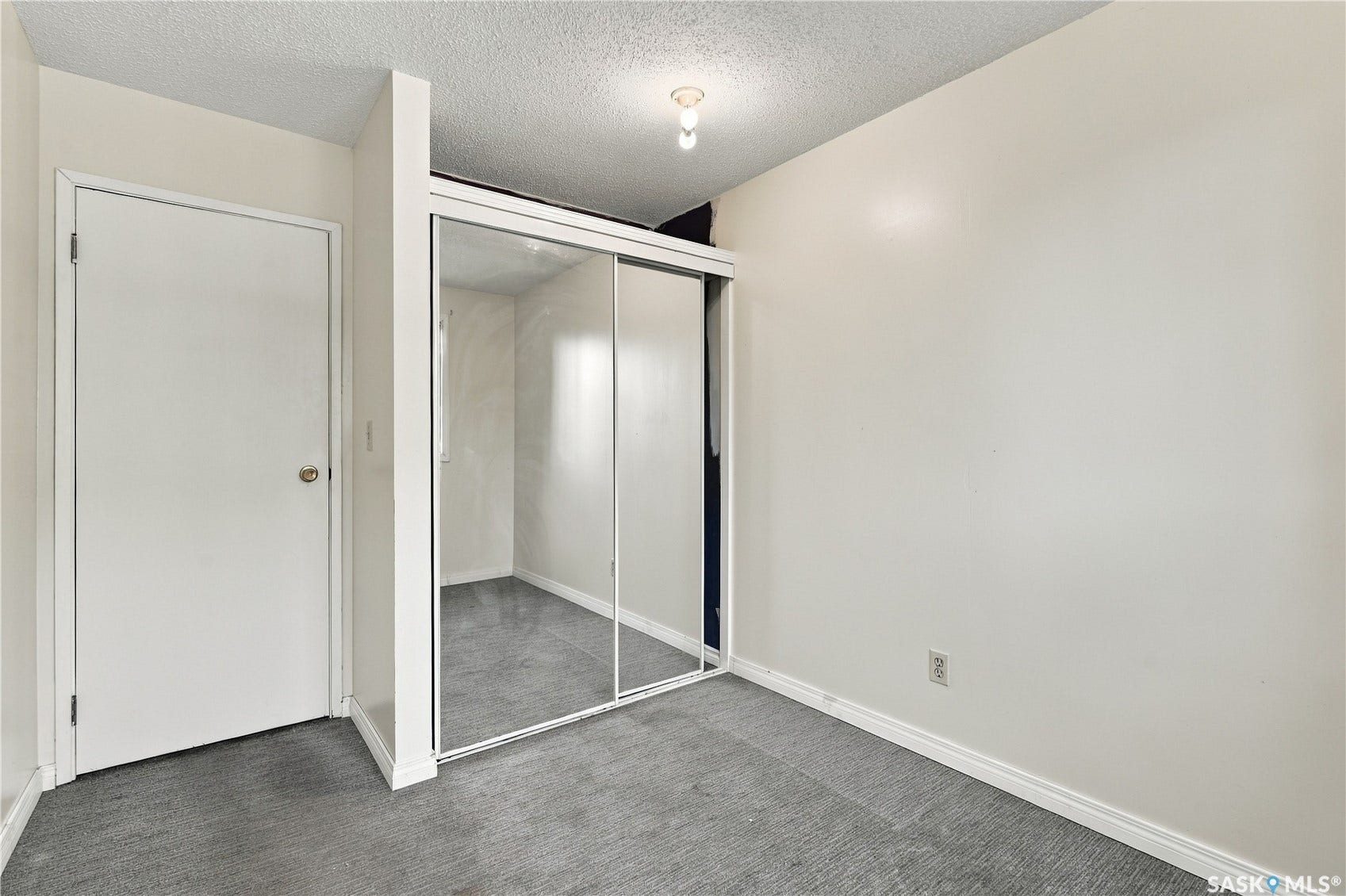 Mirrored sliding closet doors, wall-to-wall carpeting, and a flush mount ceiling fixture