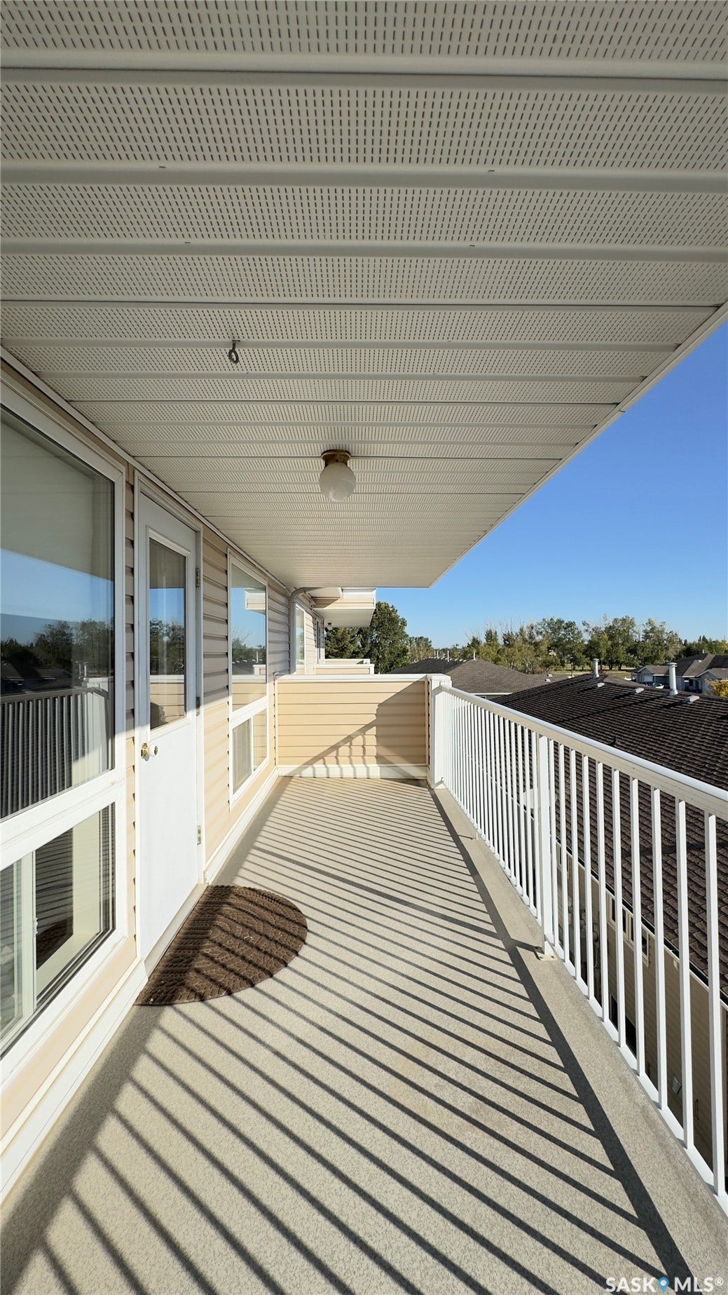 Outdoor balcony featuring durable floor coating, white railing, and exterior wall siding