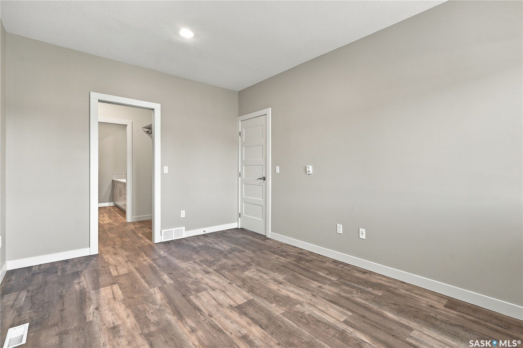 Wood-finish flooring with light gray walls, white trim, and a flush-mounted ceiling light