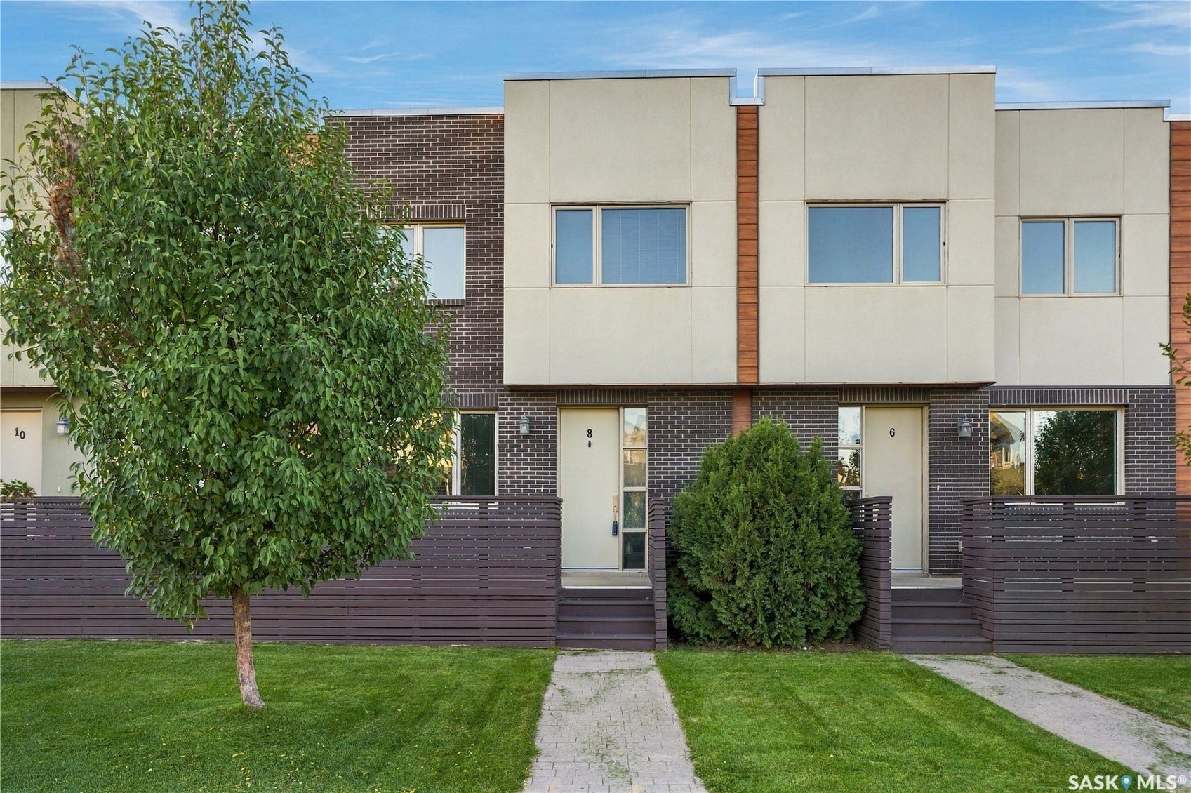 Contemporary townhome residences featuring a brick and panel facade